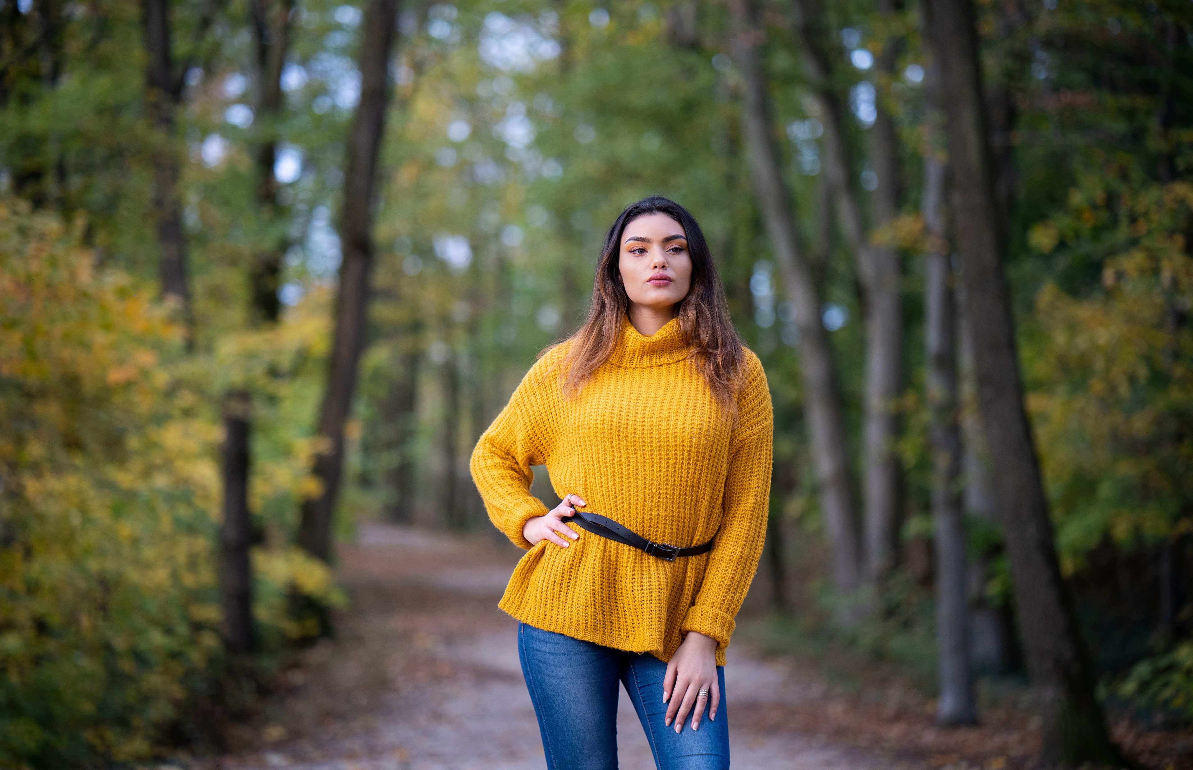 Woman in yellow sweater and jeans in forest HD Wallpaper