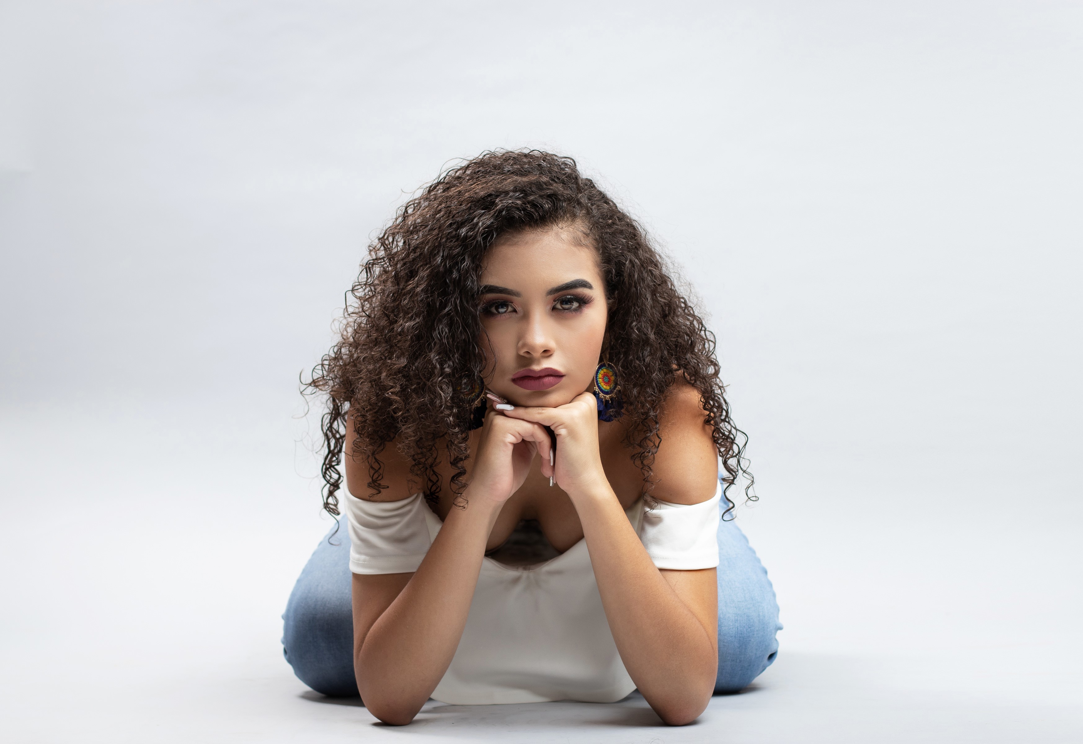 Camila with curly hair posing on a gray background HD Wallpaper