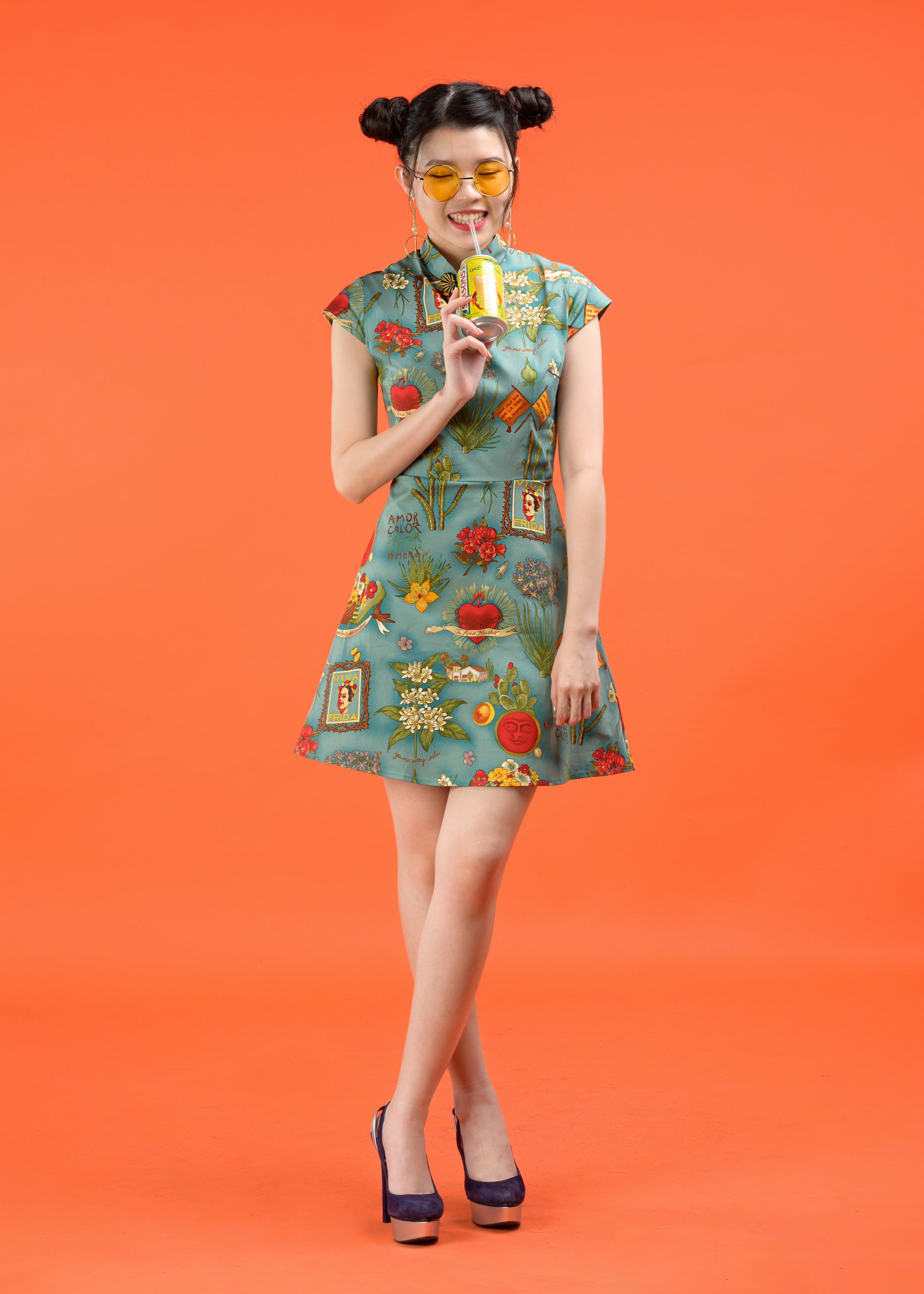 Woman in a patterned dress drinking from a can HD Phone Wallpaper
