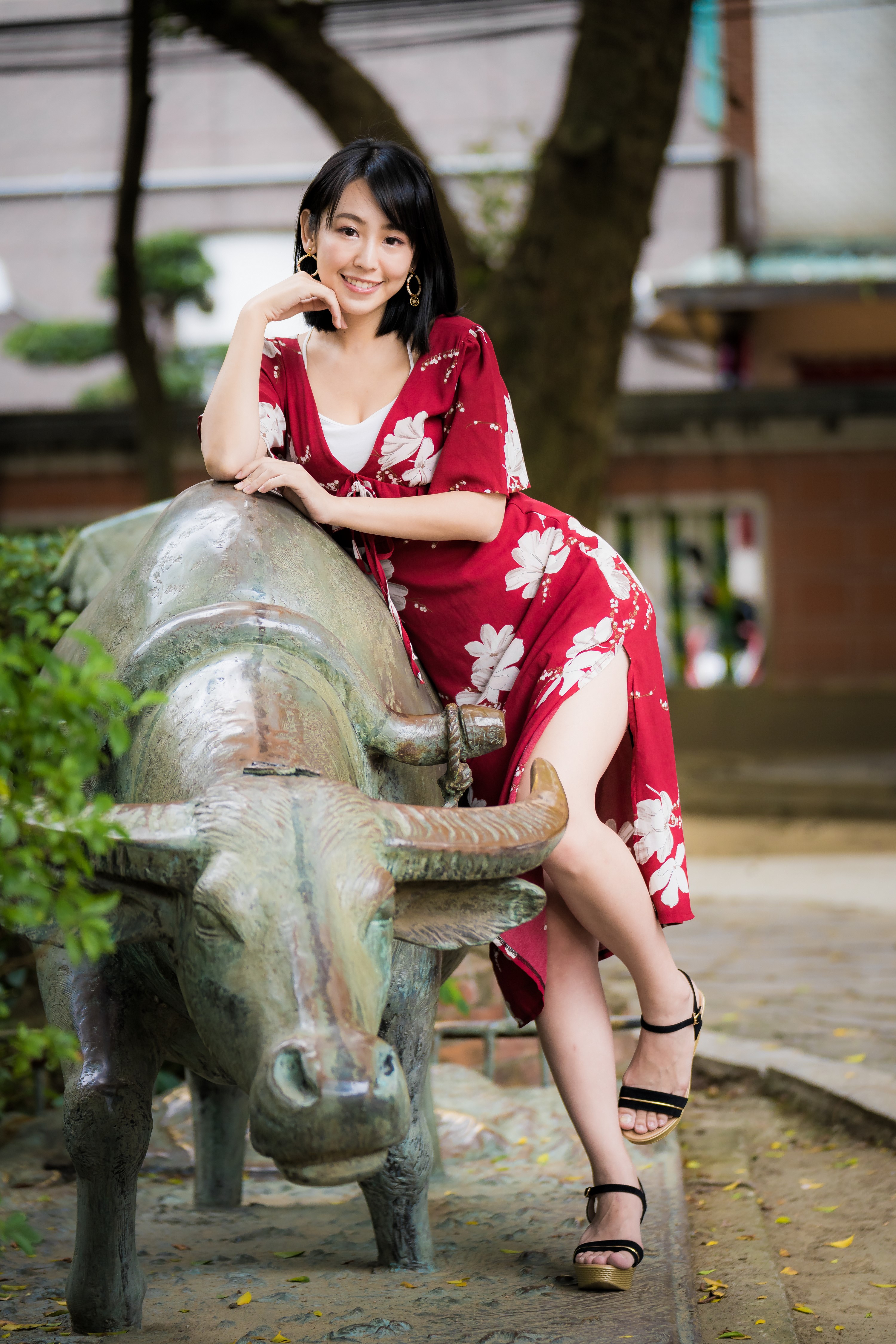 Woman in red dress posing with buffalo statue HD Phone Wallpaper