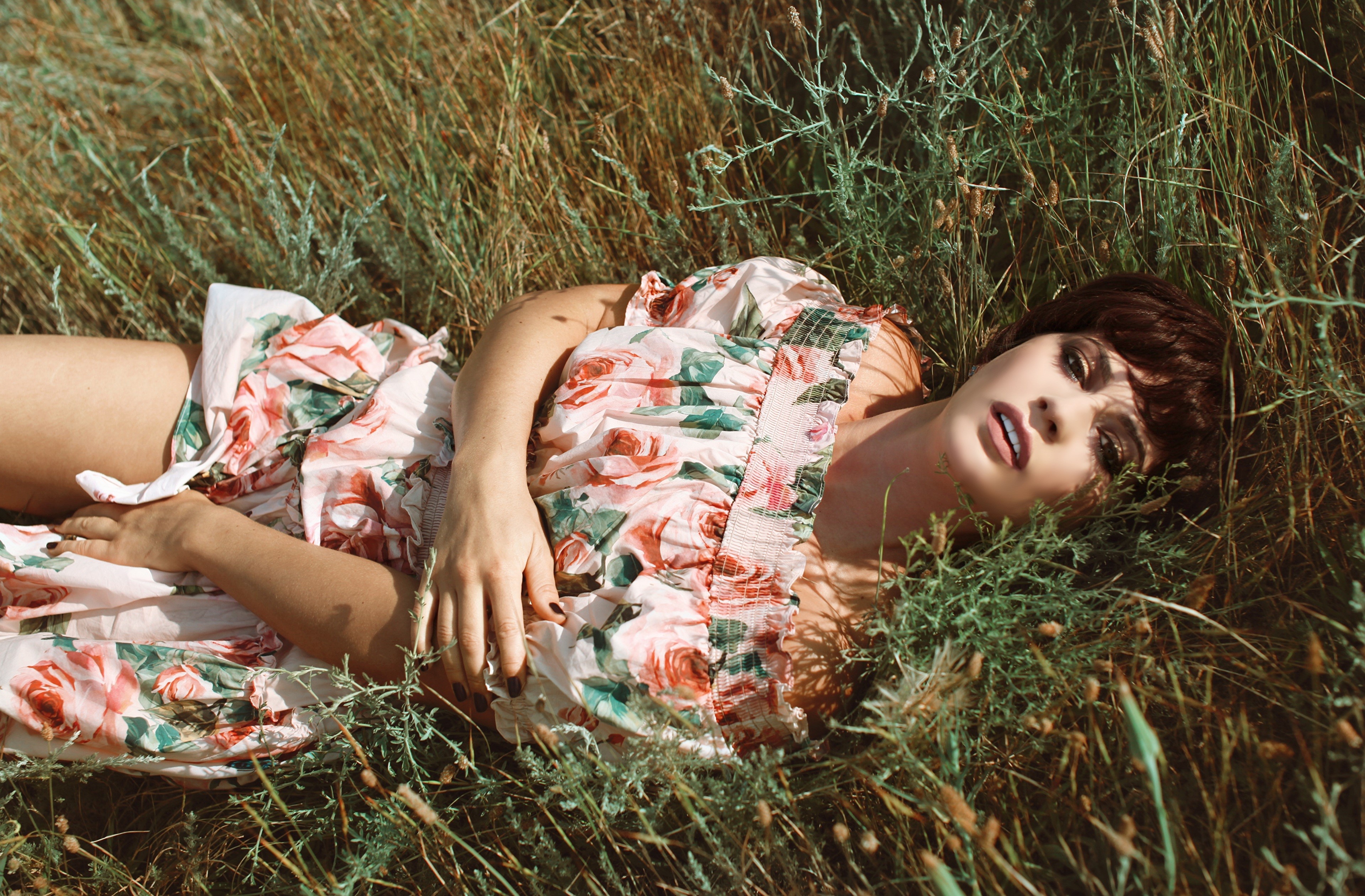 Woman in floral dress lying in grass HD Wallpaper