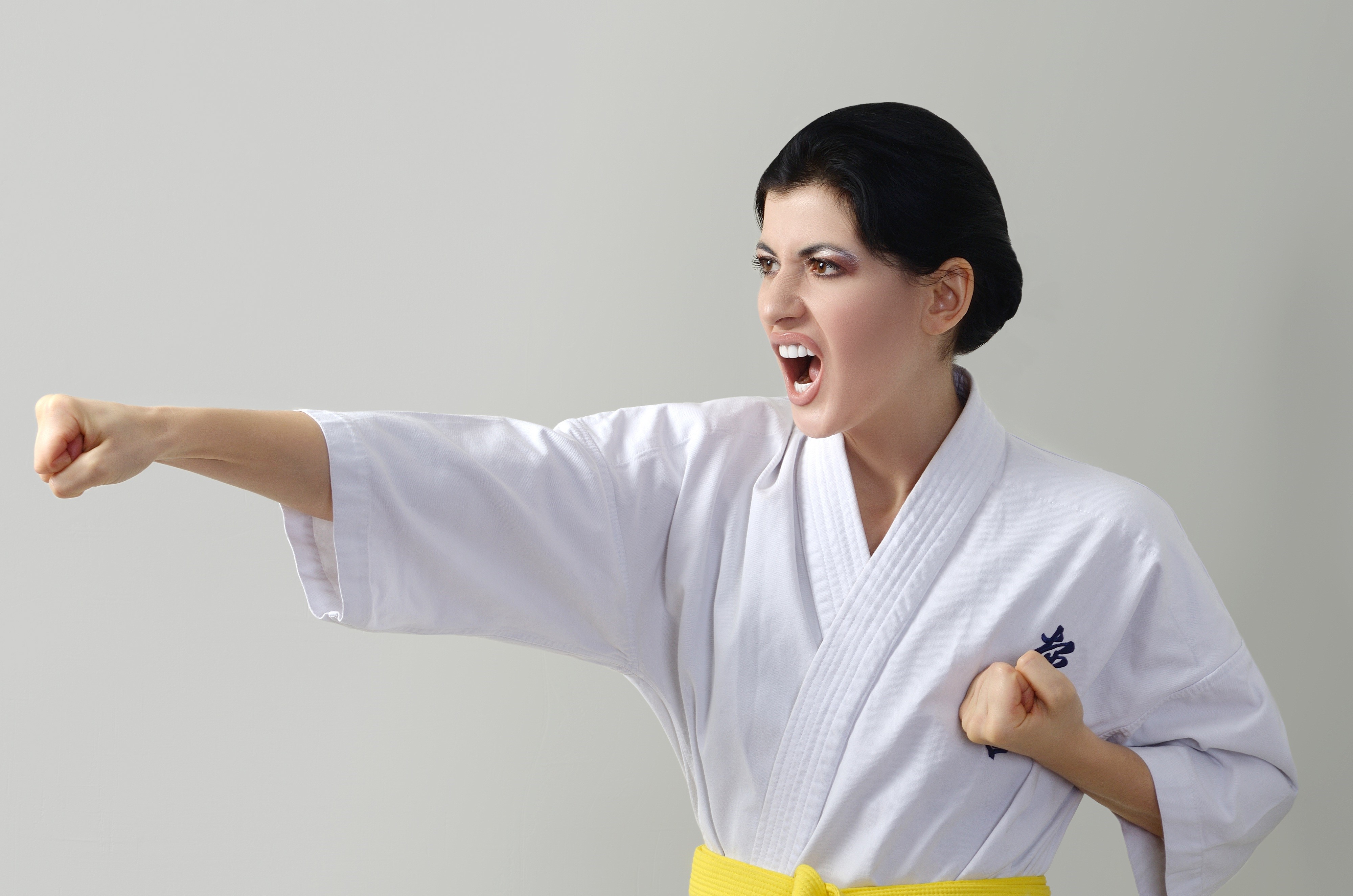 Woman in Karate Uniform Performing a Punch HD Wallpaper