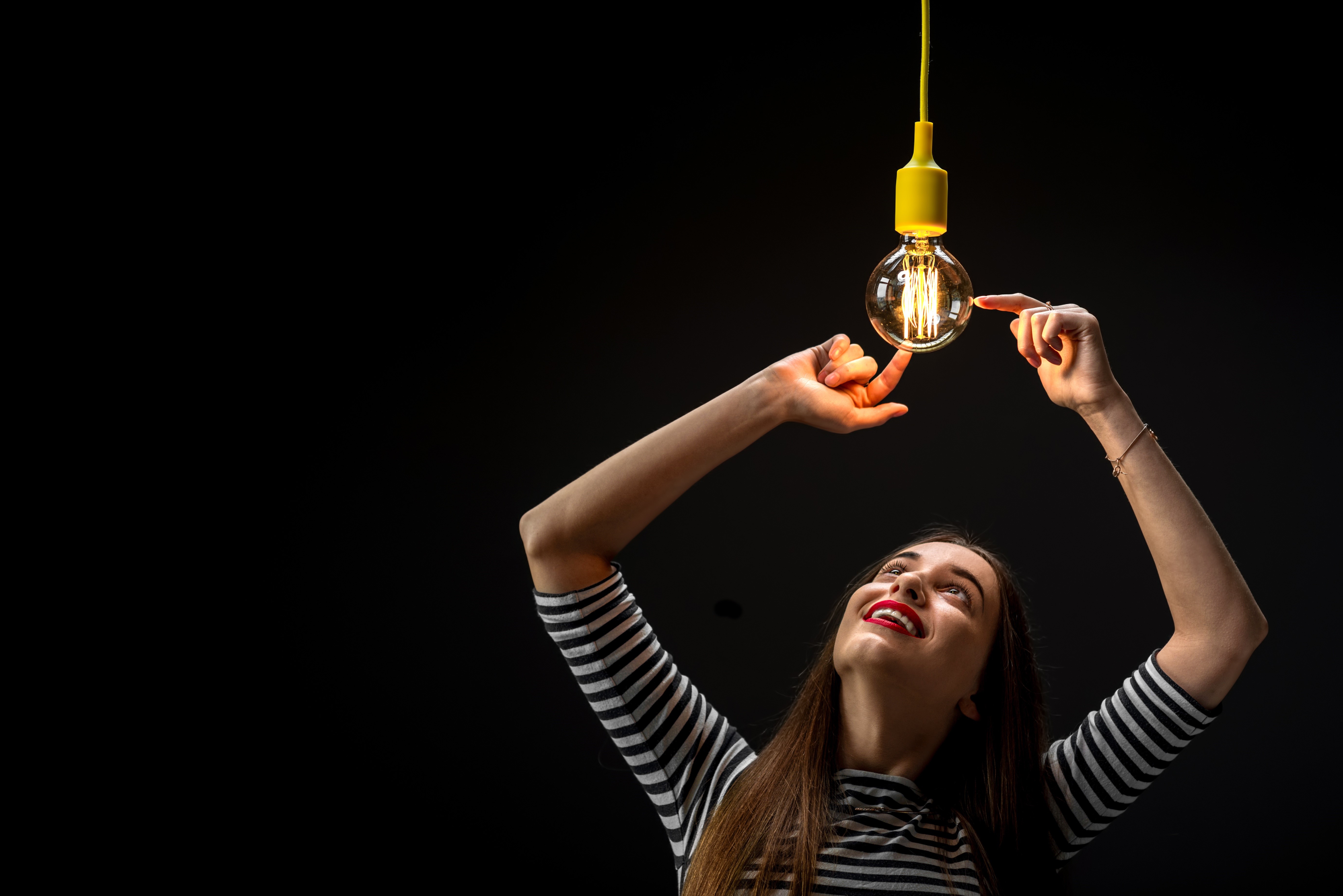 Woman touching a light bulb HD Wallpaper