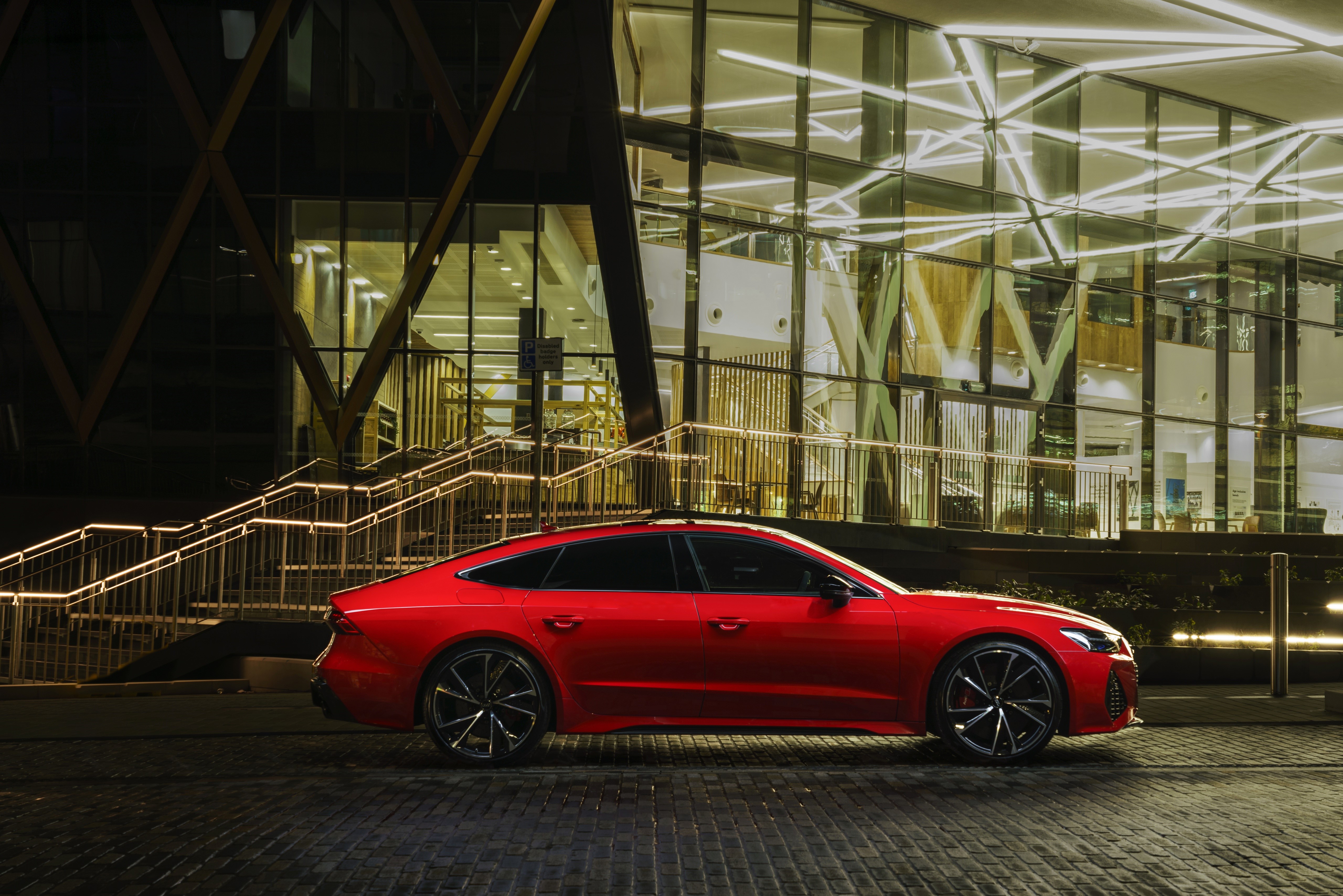 Red Audi RS7 Sportback parked outside modern building HD Wallpaper