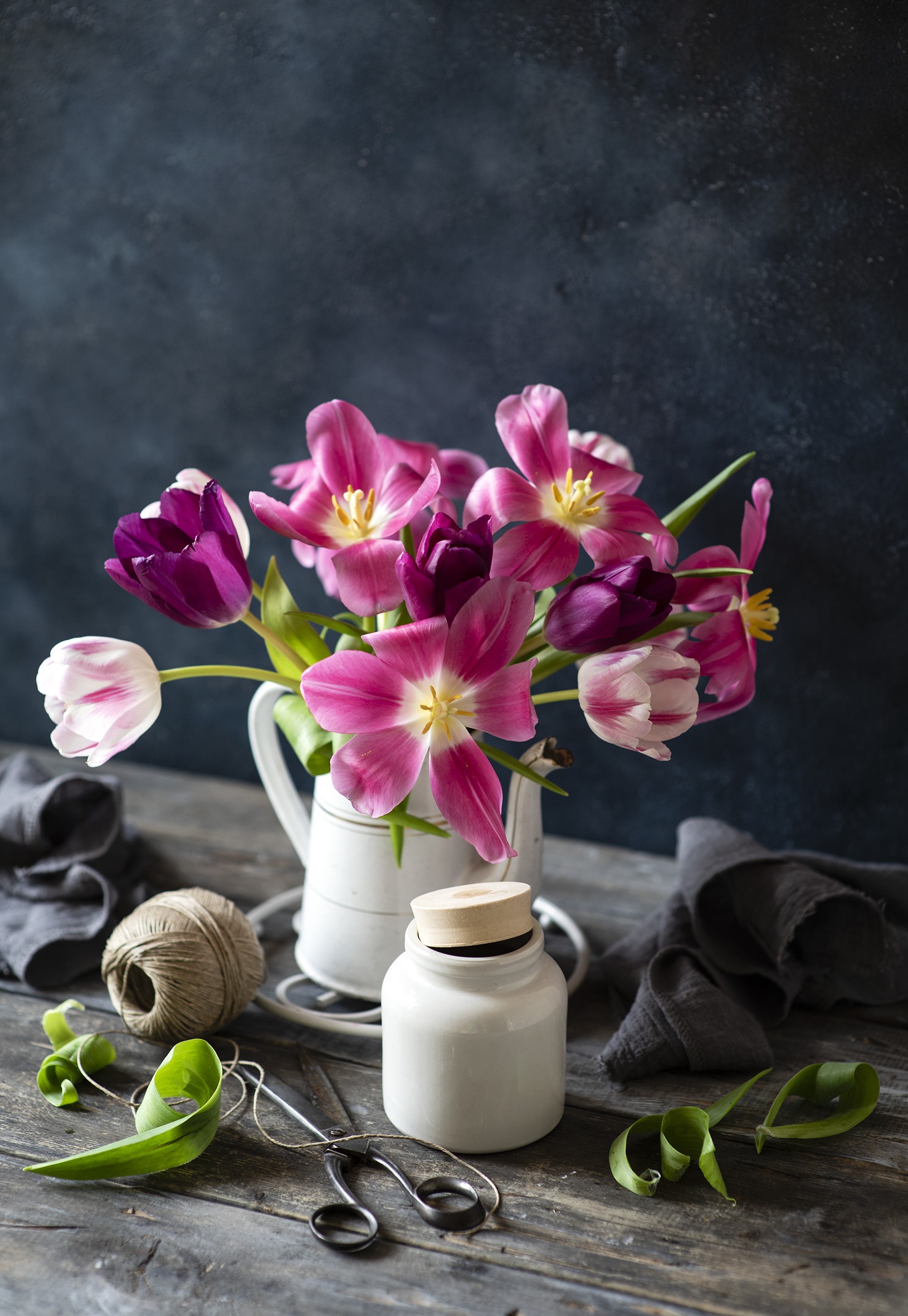 Pink and purple tulips in a white vase on a wooden table HD Phone Wallpaper
