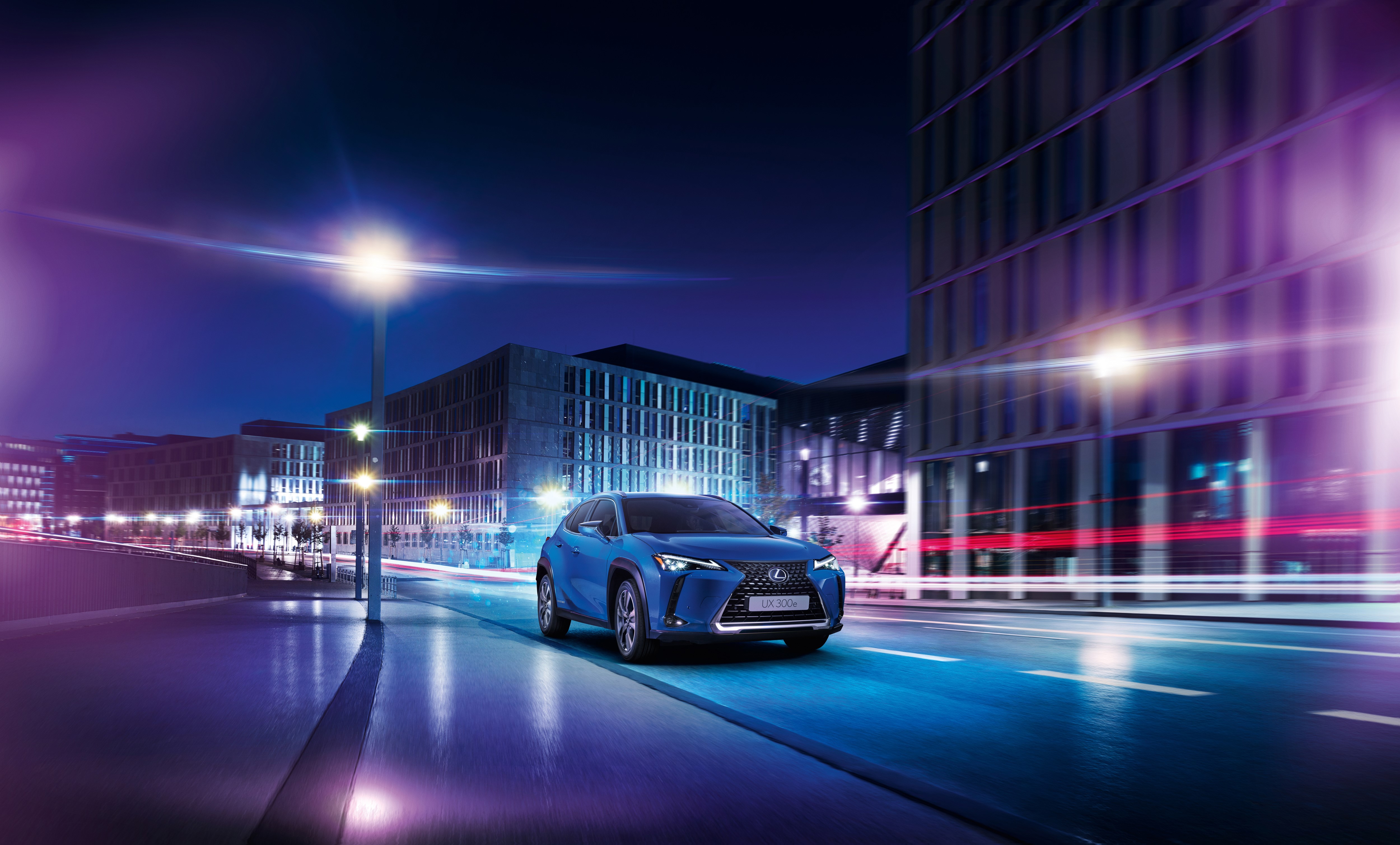 Lexus UX 300e driving in a city at night HD Wallpaper