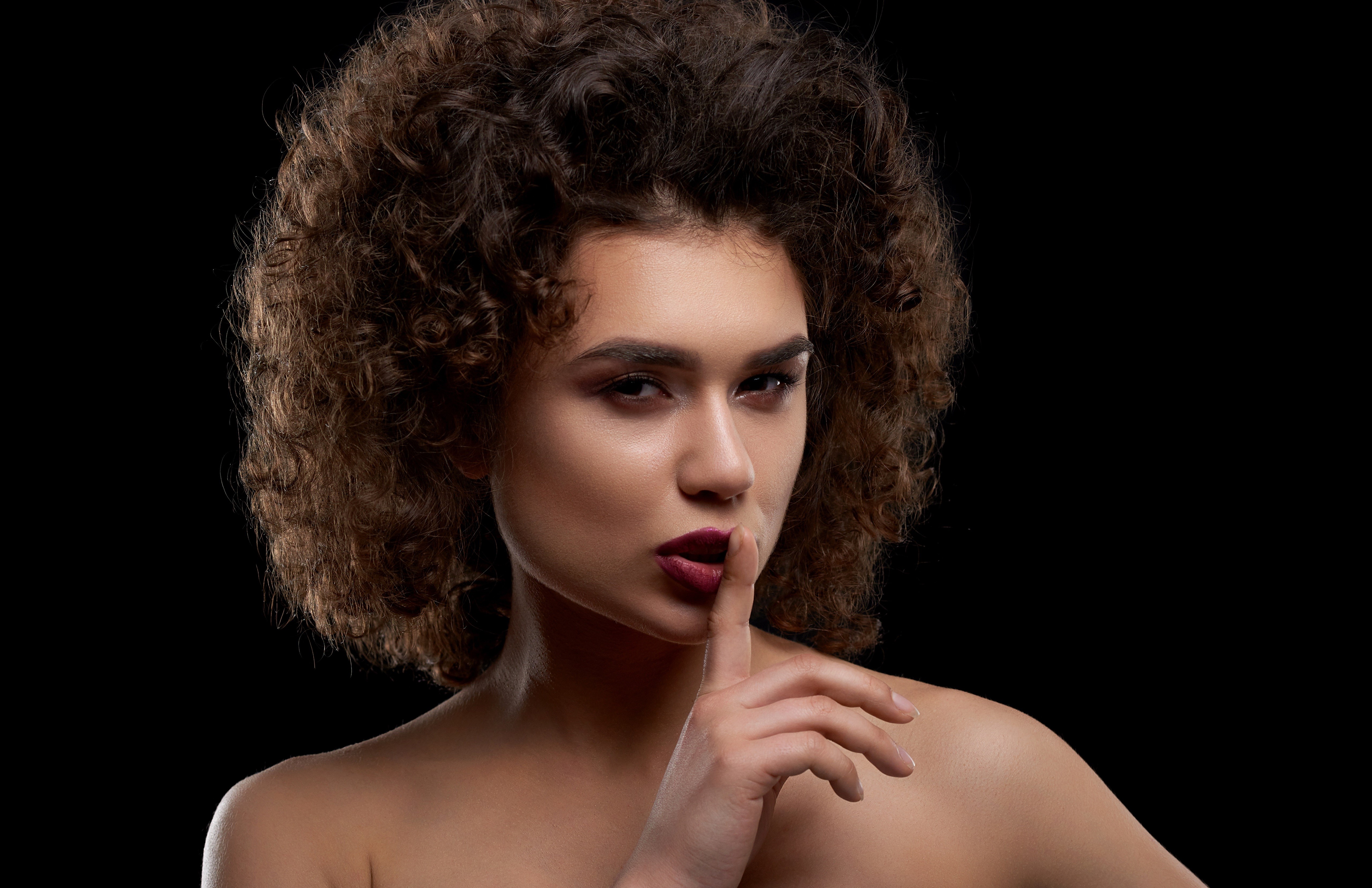 Model with curly hair and makeup gesture HD Wallpaper