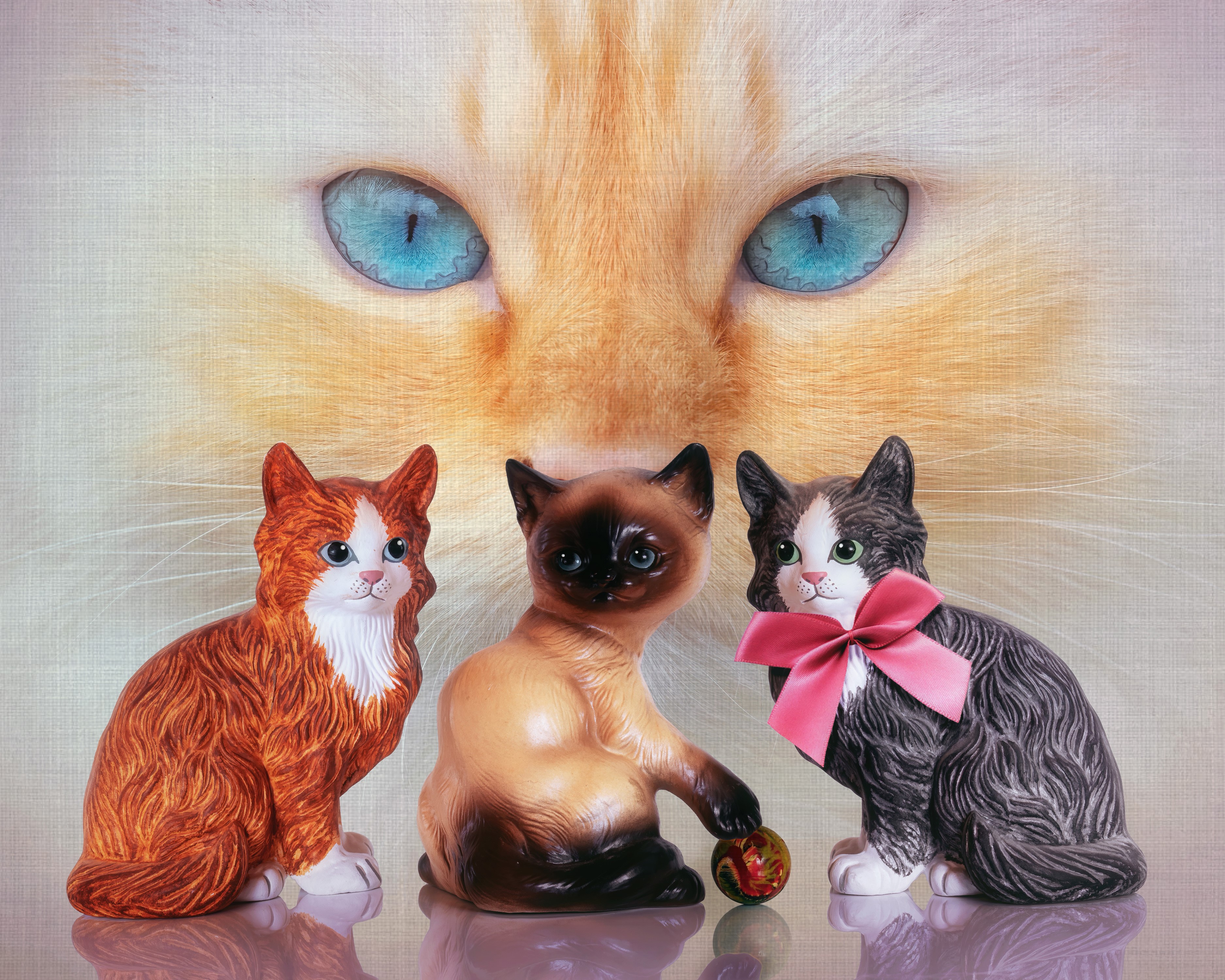 Three cat sculptures in front of a large cat face painting HD Wallpaper