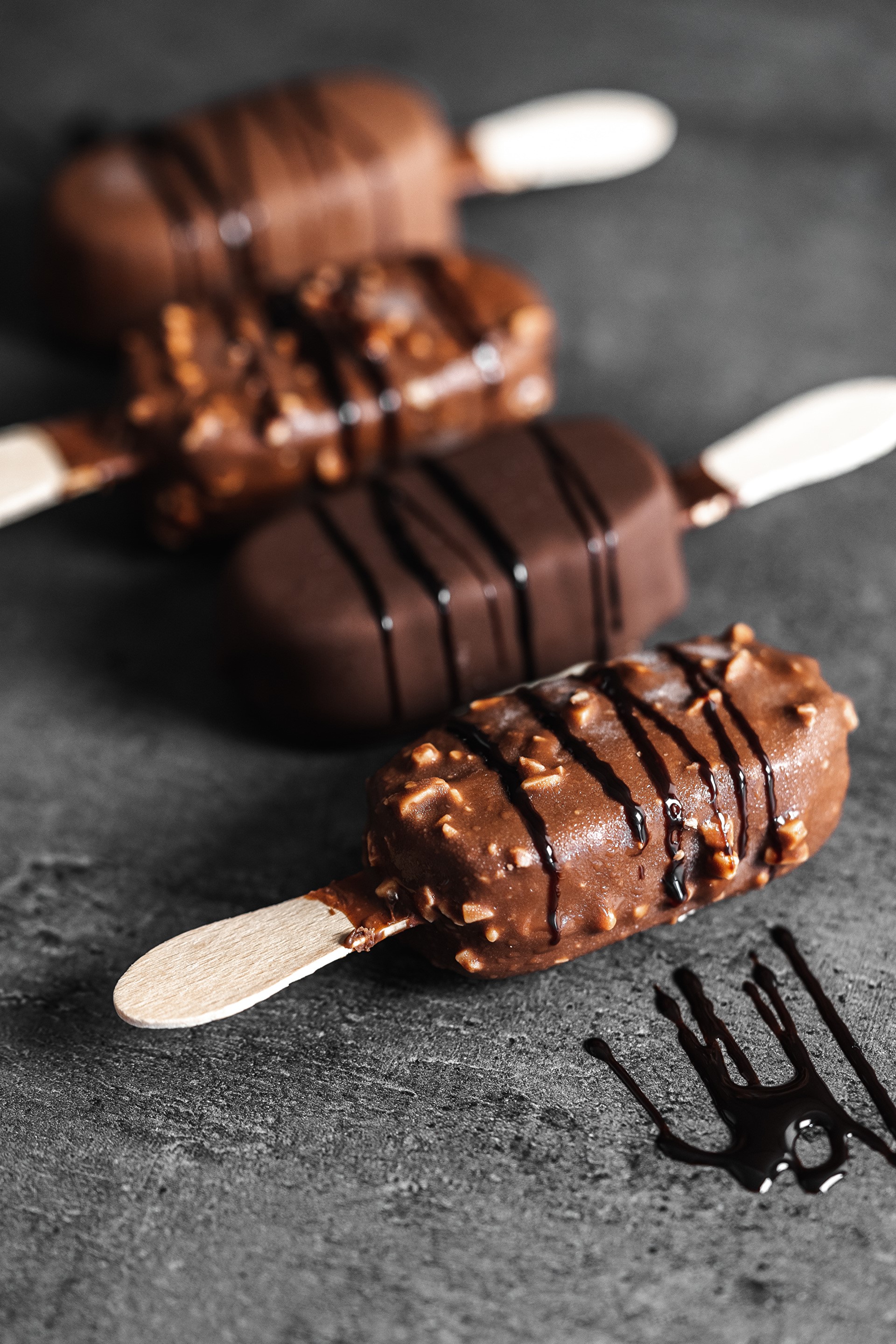 Chocolate ice cream bars with nuts and chocolate drizzle HD Phone Wallpaper