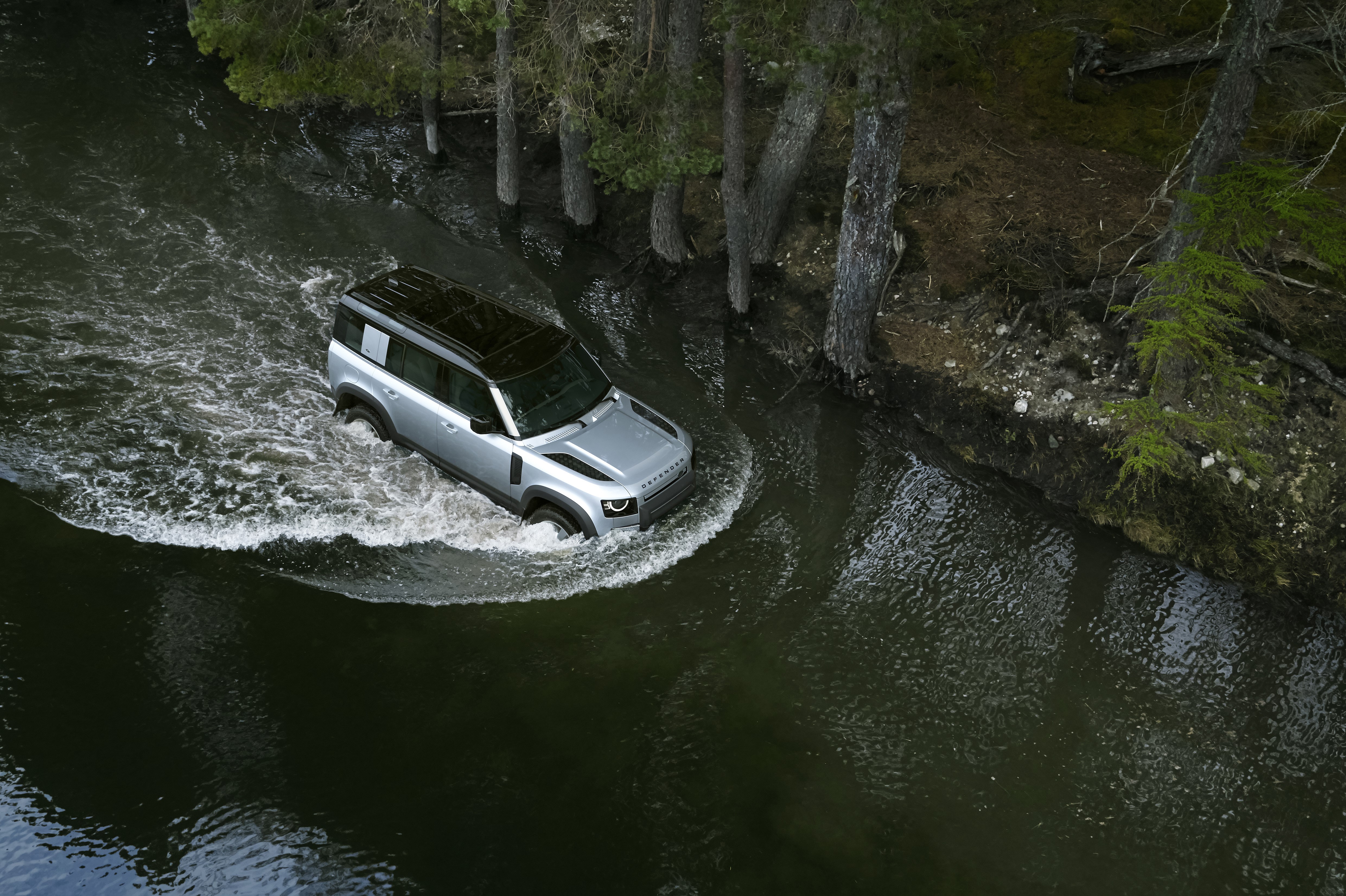 Silver Land Rover Defender 110 driving through water HD Wallpaper