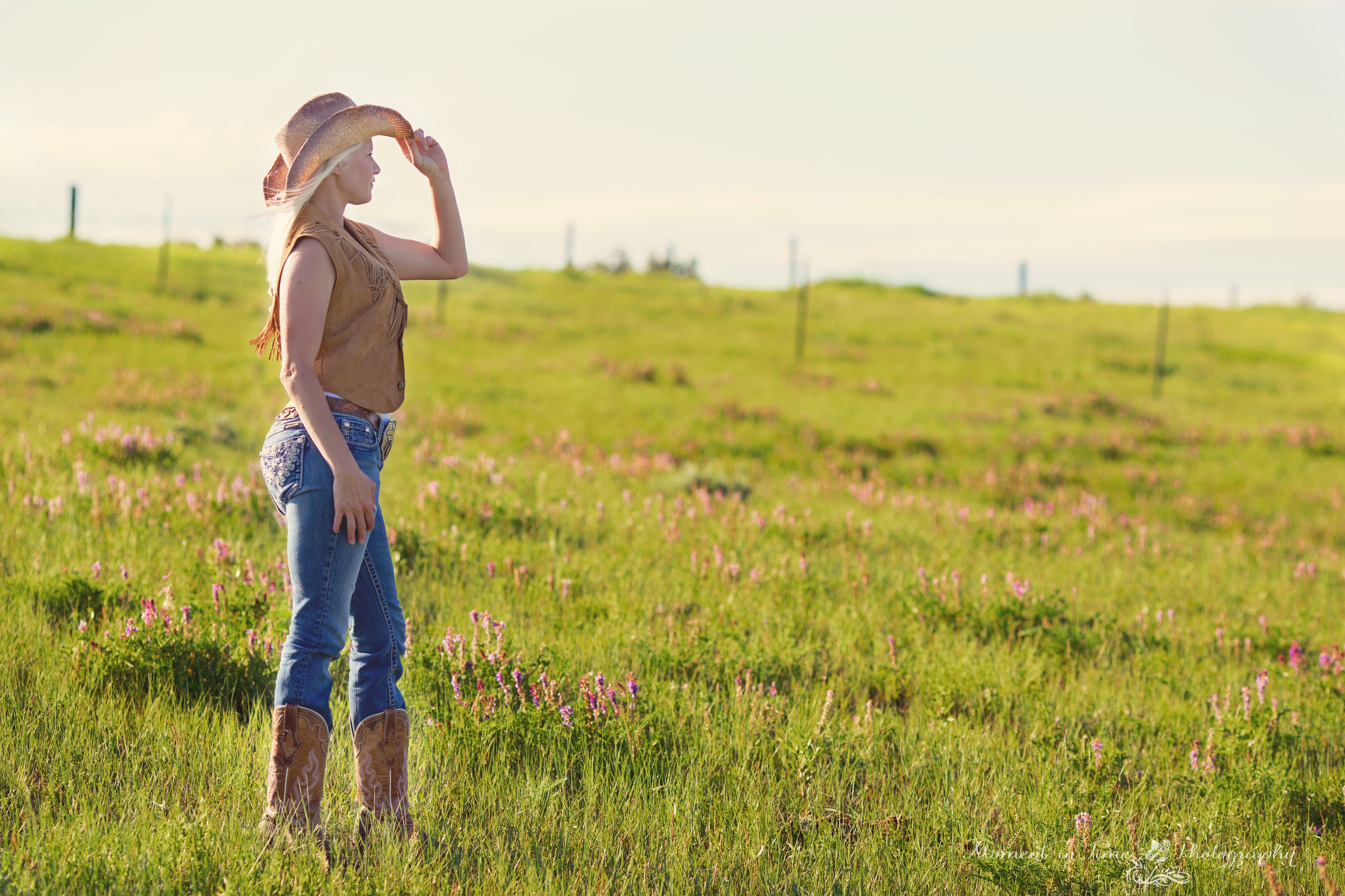 Blonde girl in cowboy hat and jeans in grasslands HD Wallpaper