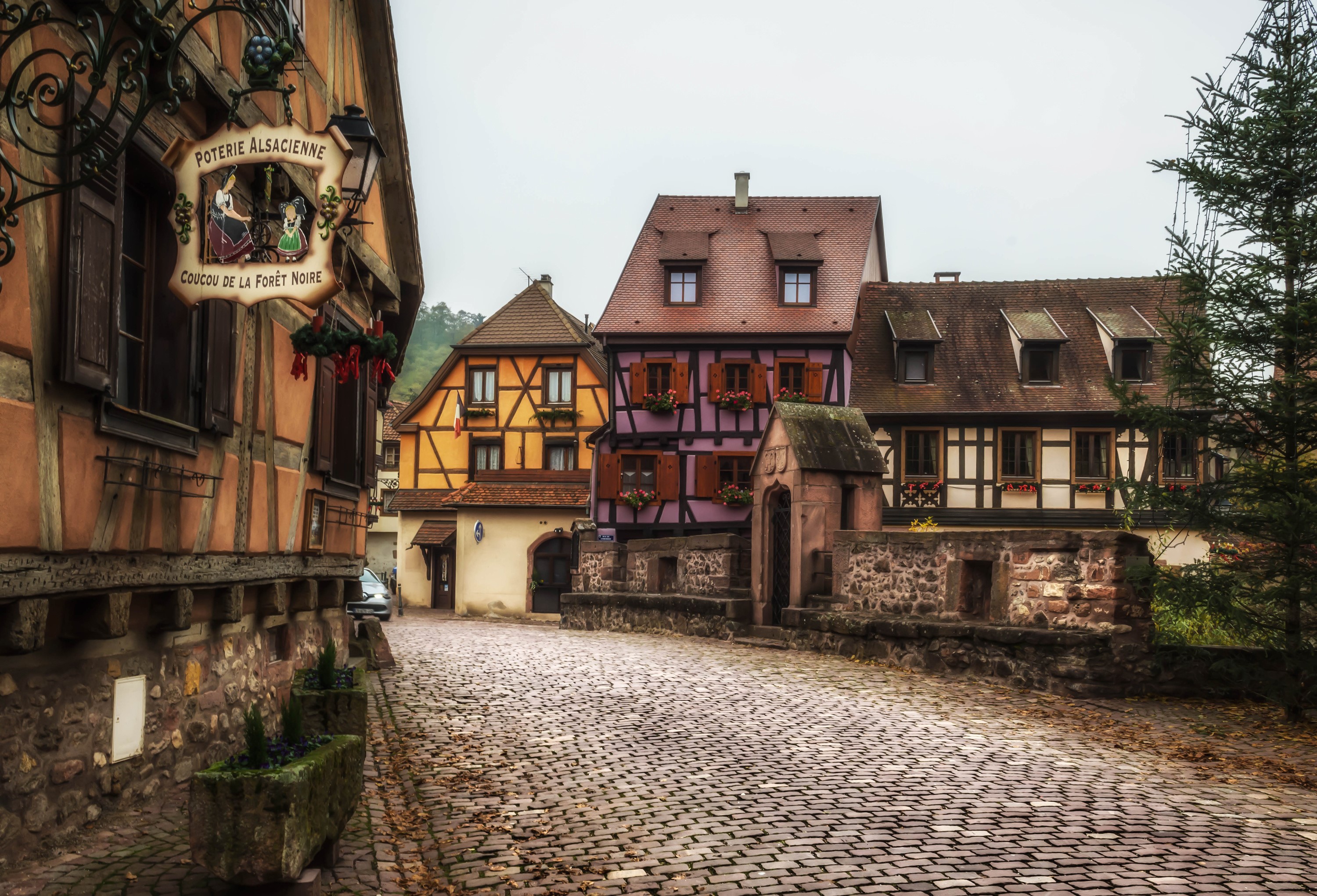 Cobblestone street in Kaysersberg, France with traditional houses HD Wallpaper