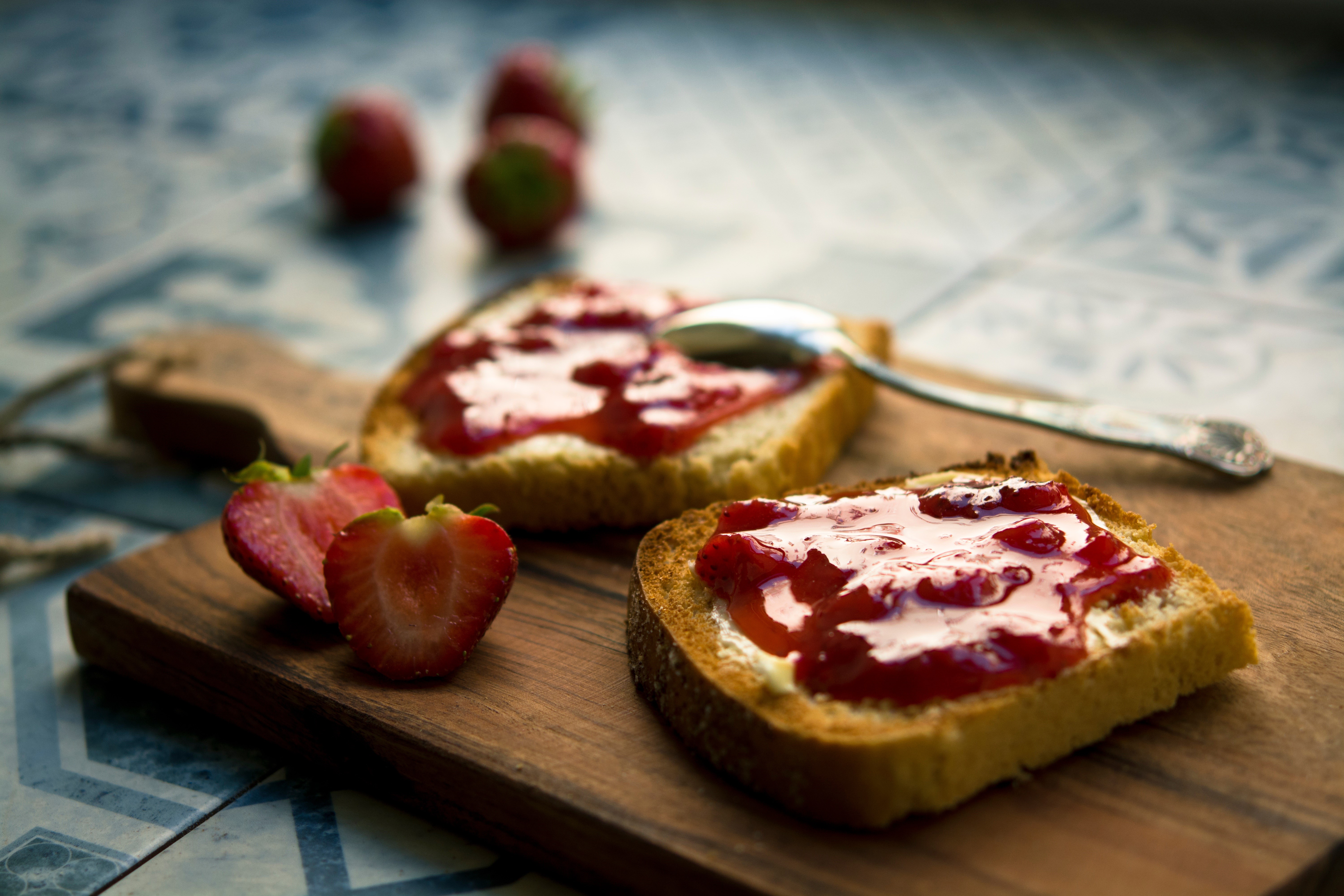 Bread with strawberry jam and strawberries on a cutting board HD Wallpaper