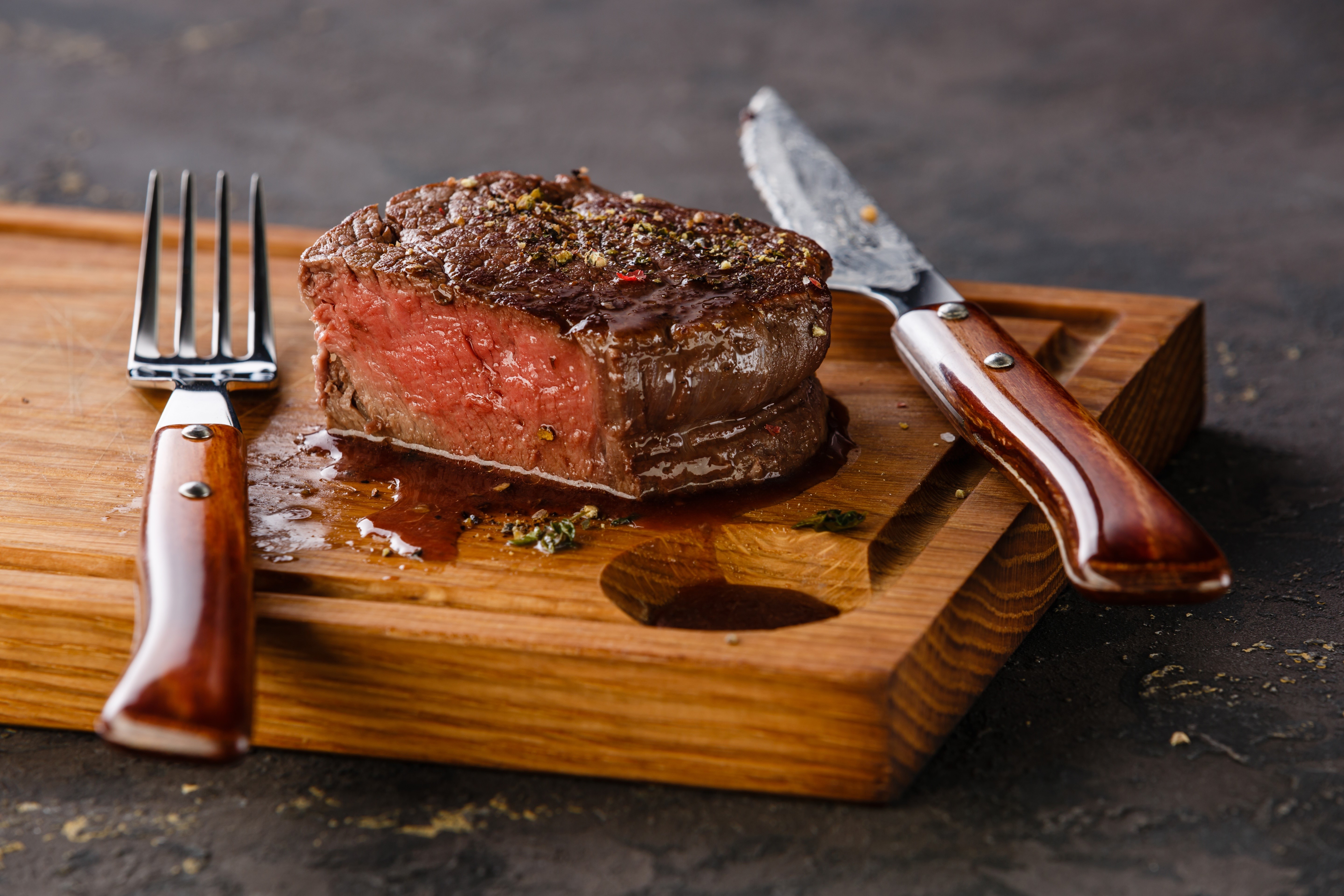 Beef steak with fork and knife on cutting board HD Wallpaper