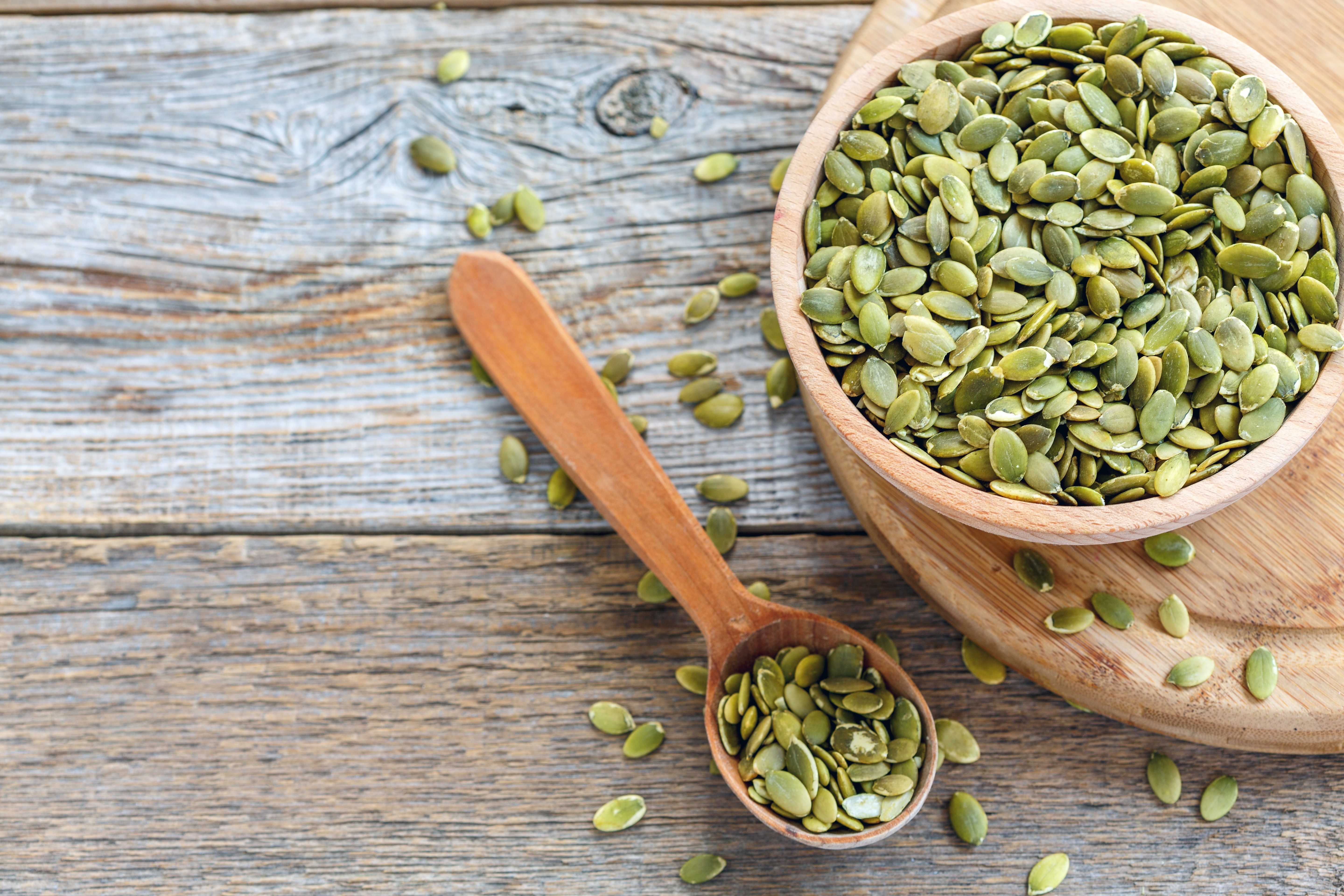 Pumpkin seeds in a bowl and spoon HD Wallpaper