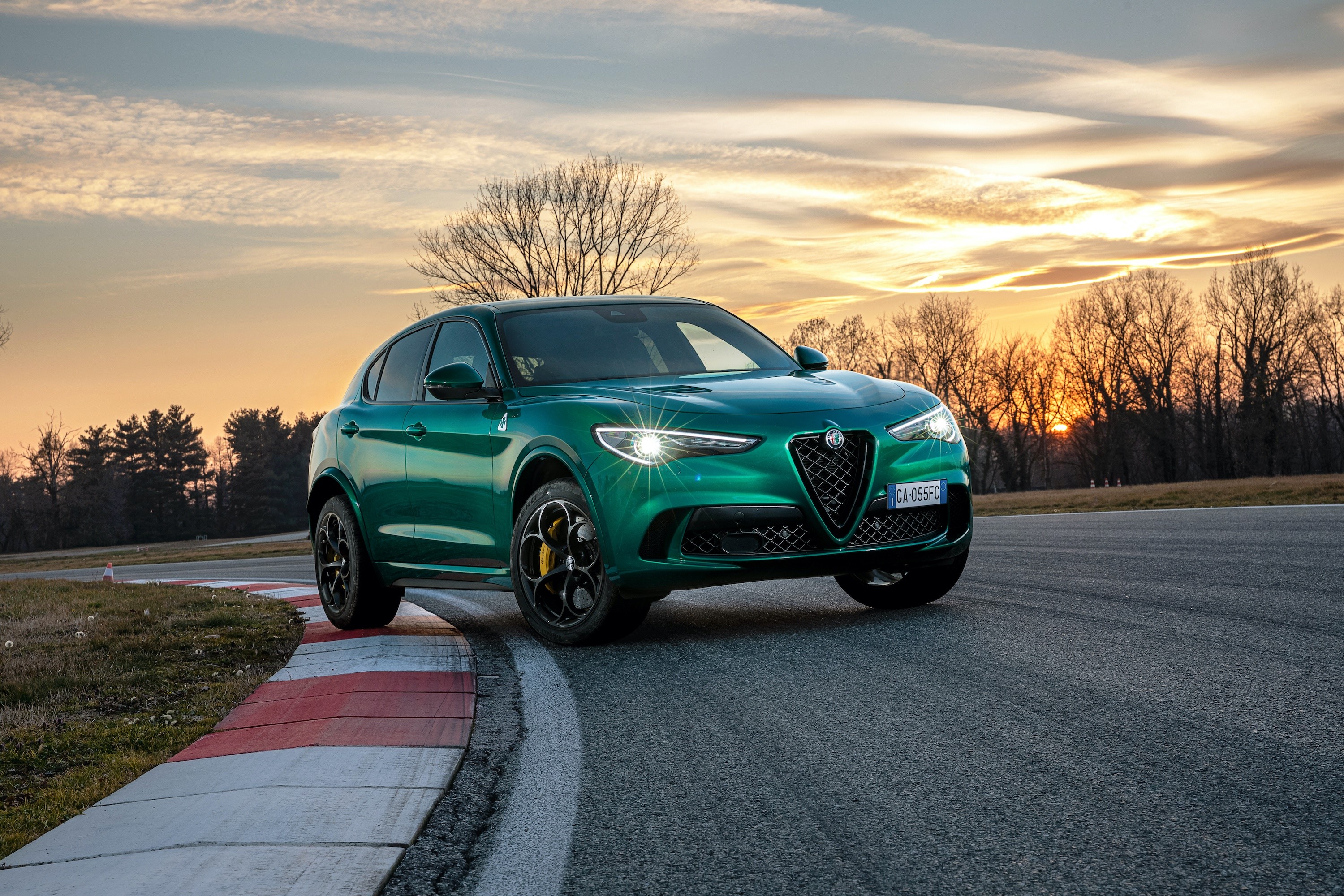 Green Alfa Romeo Stelvio Quadrifoglio on a track at sunset HD Wallpaper