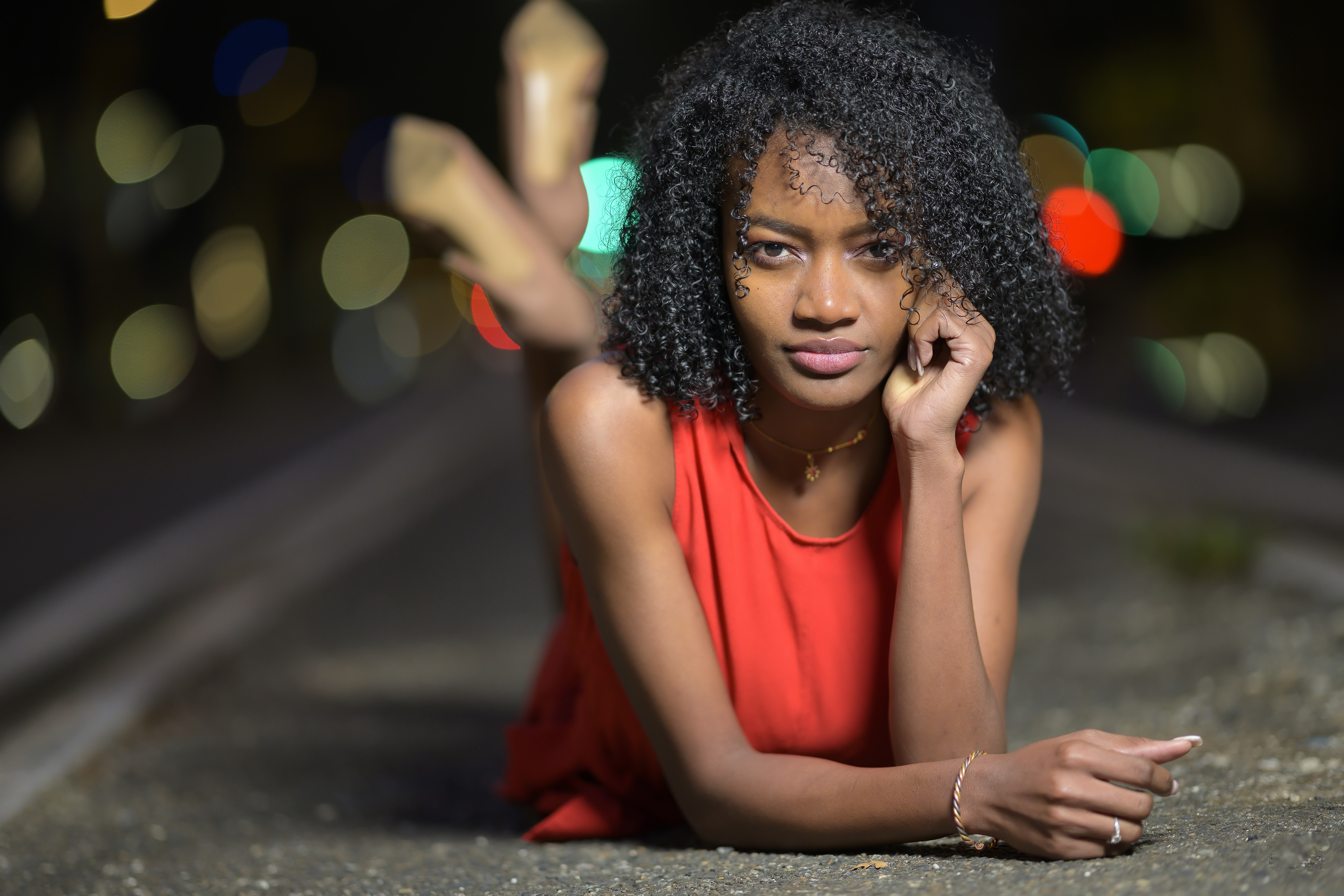 Woman with curly hair in red dress at night HD Wallpaper