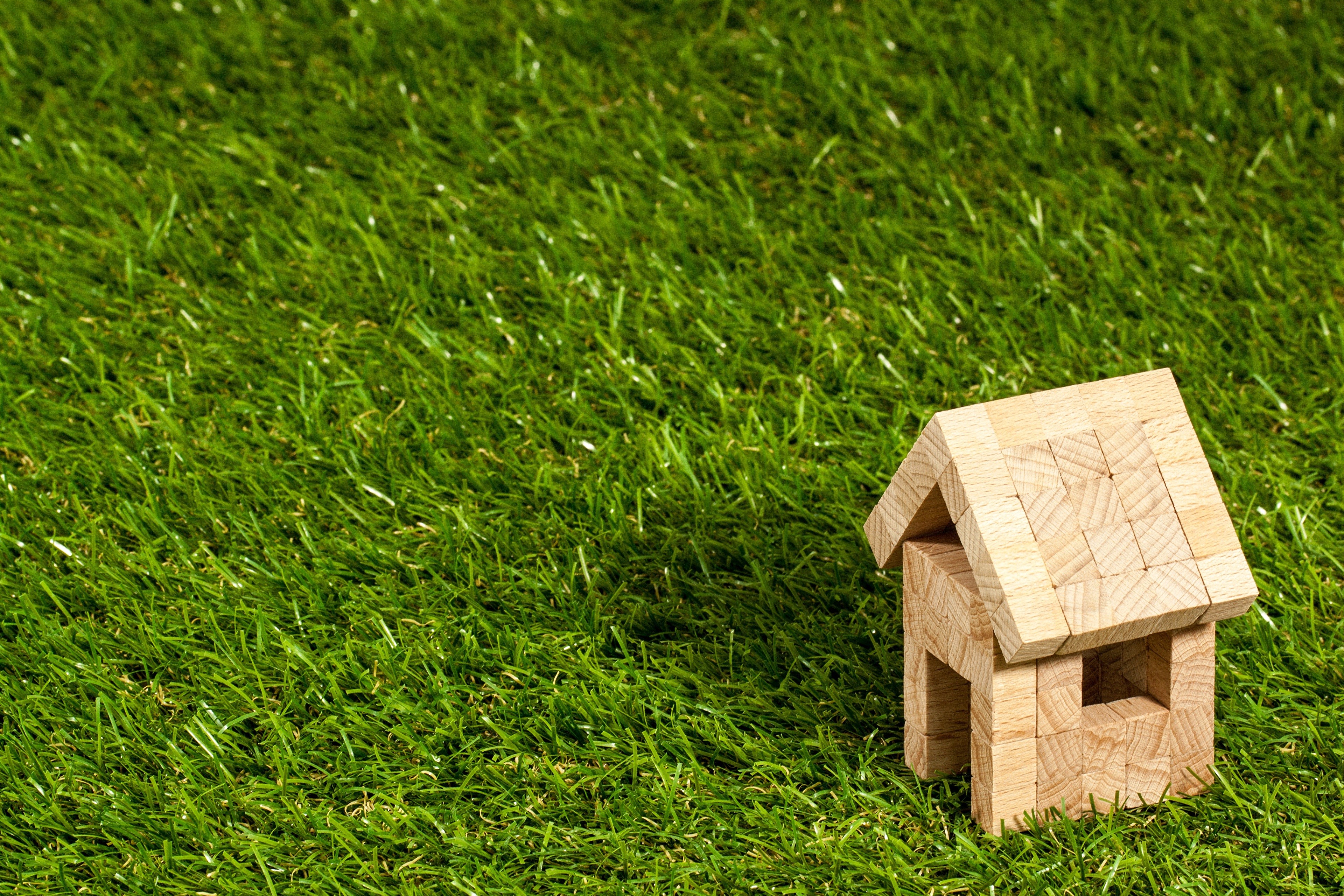Wooden toy house on green grass HD Wallpaper