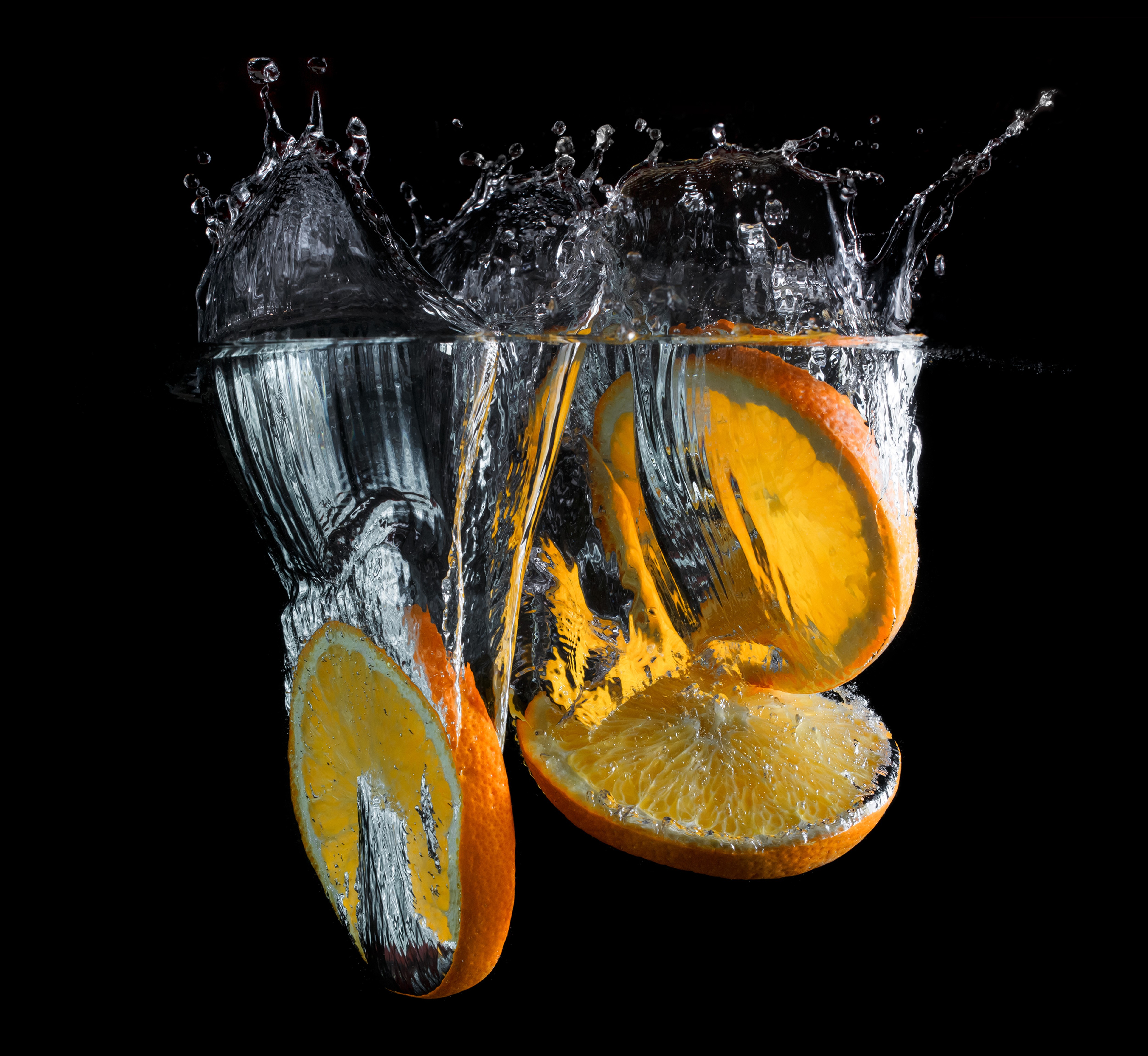 Orange slices splashing into water HD Wallpaper
