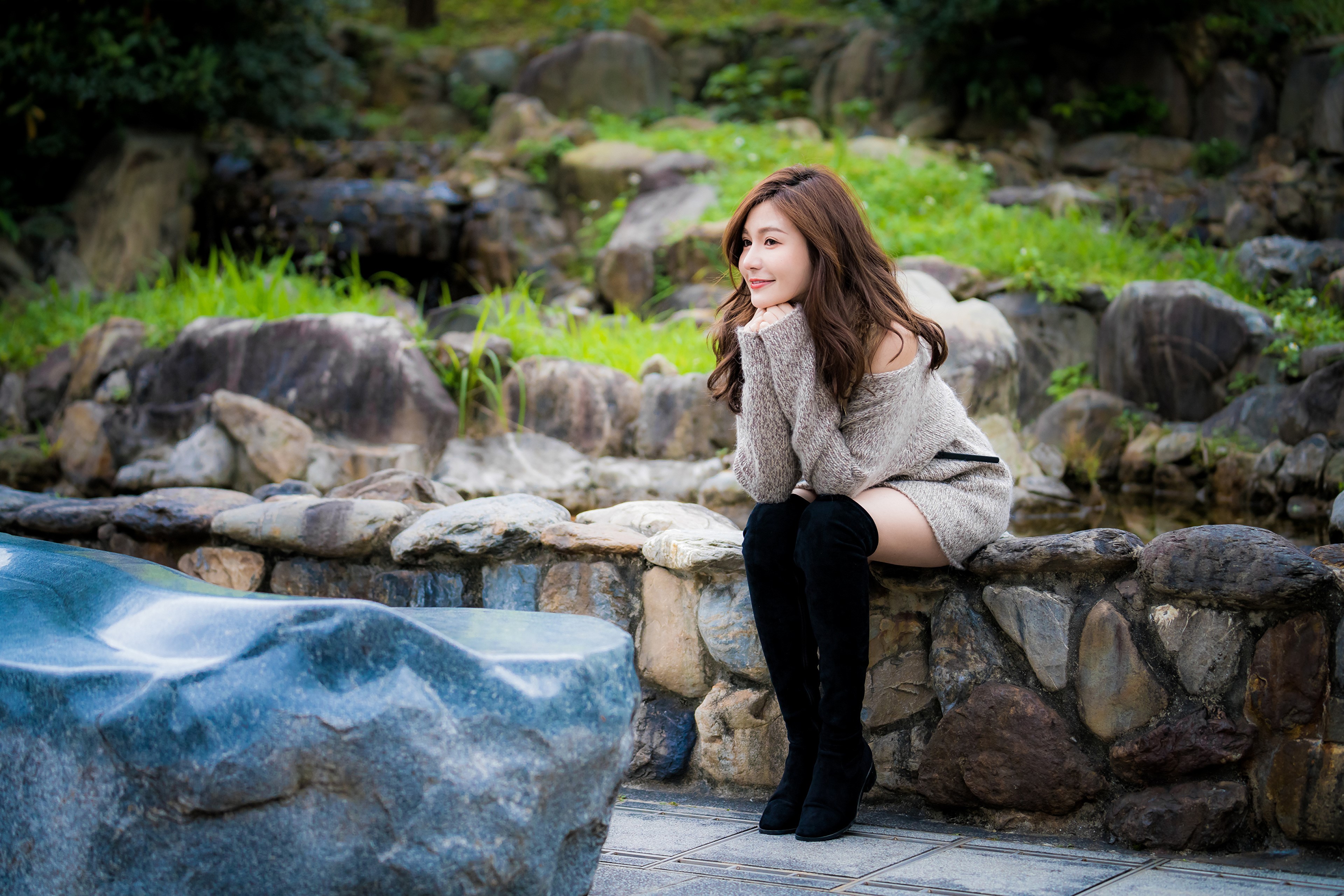 Asian woman sitting on stones wearing boots HD Wallpaper