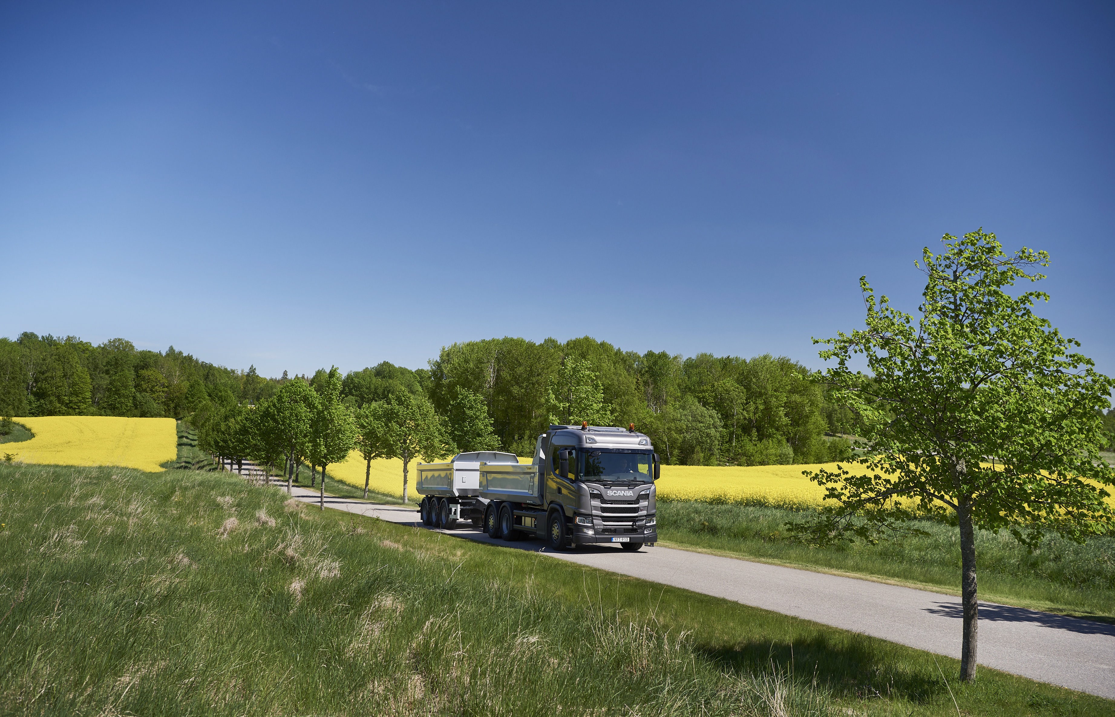 Scania truck with trailer on a rural road HD Wallpaper