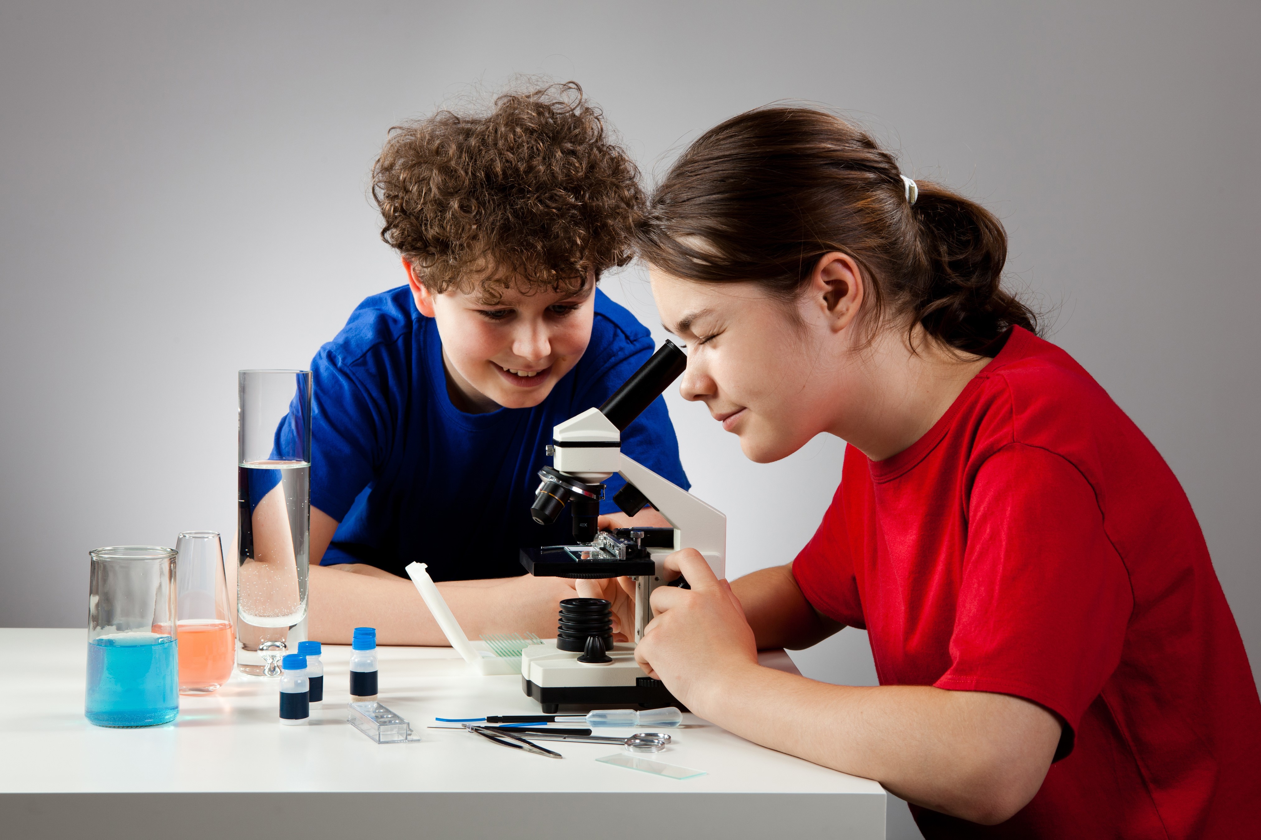 Two children using a microscope HD Wallpaper
