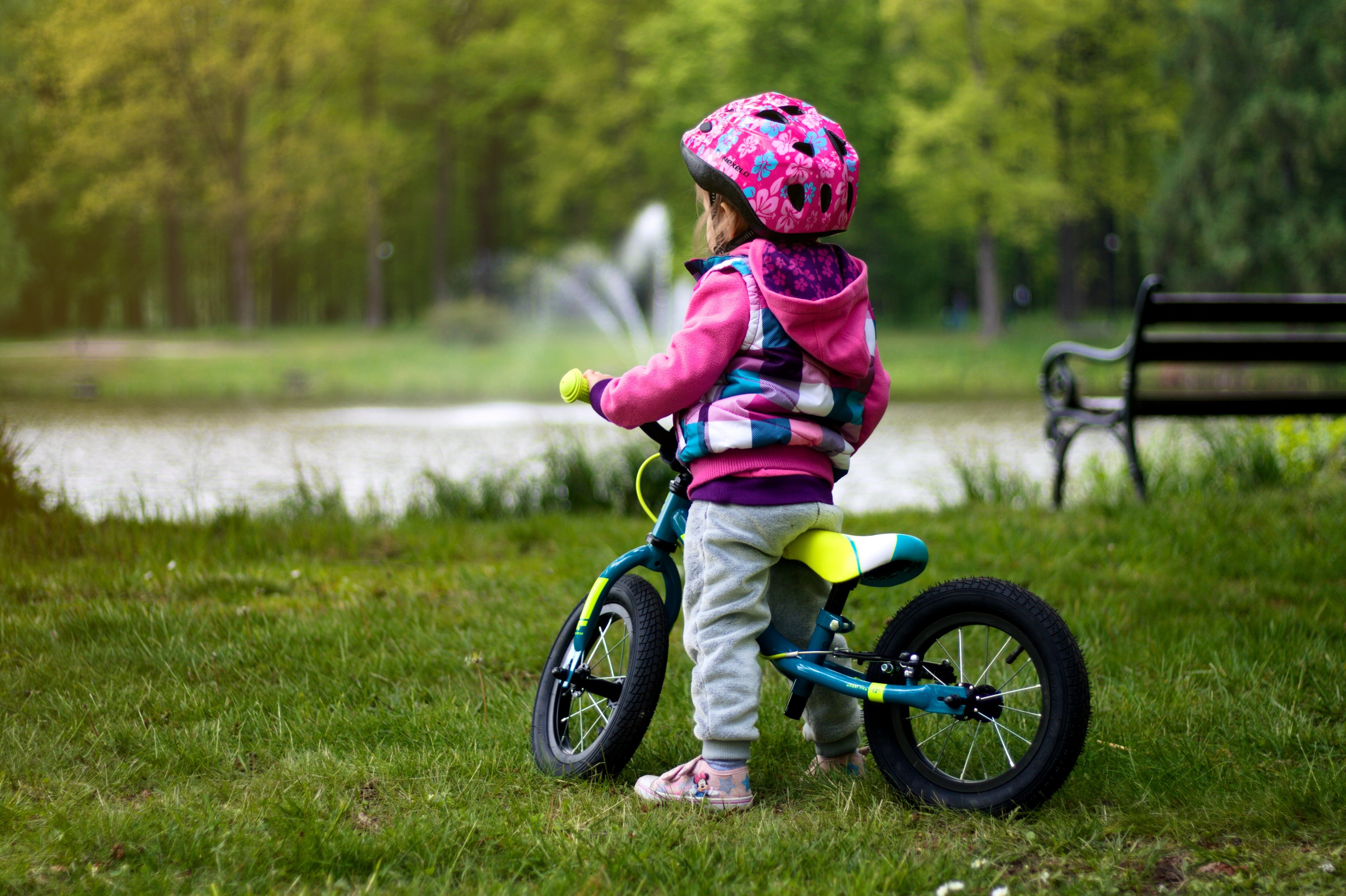 Little girl with bicycle and helmet in park HD Wallpaper