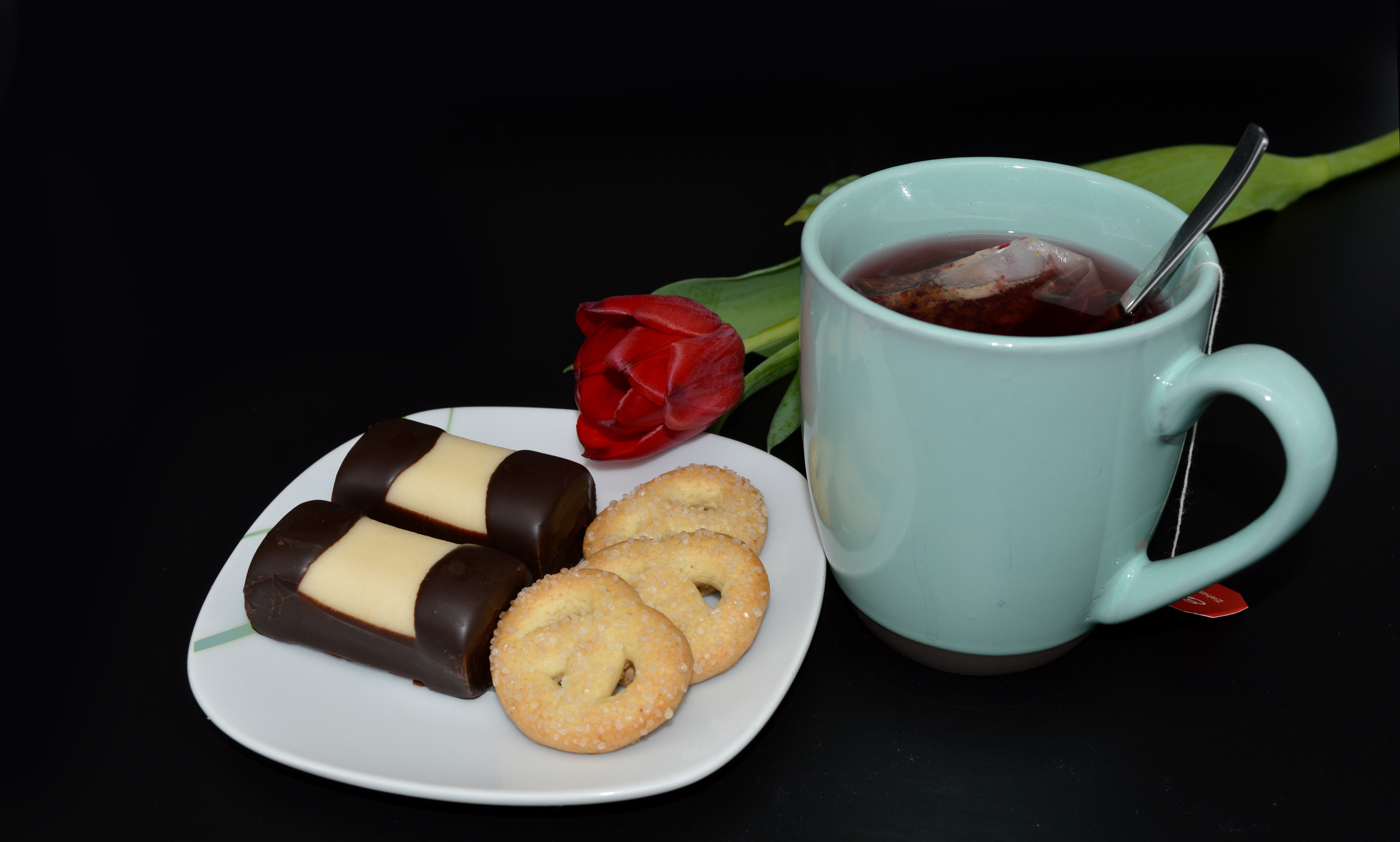 Tea with cookies and a tulip on a black background HD Wallpaper