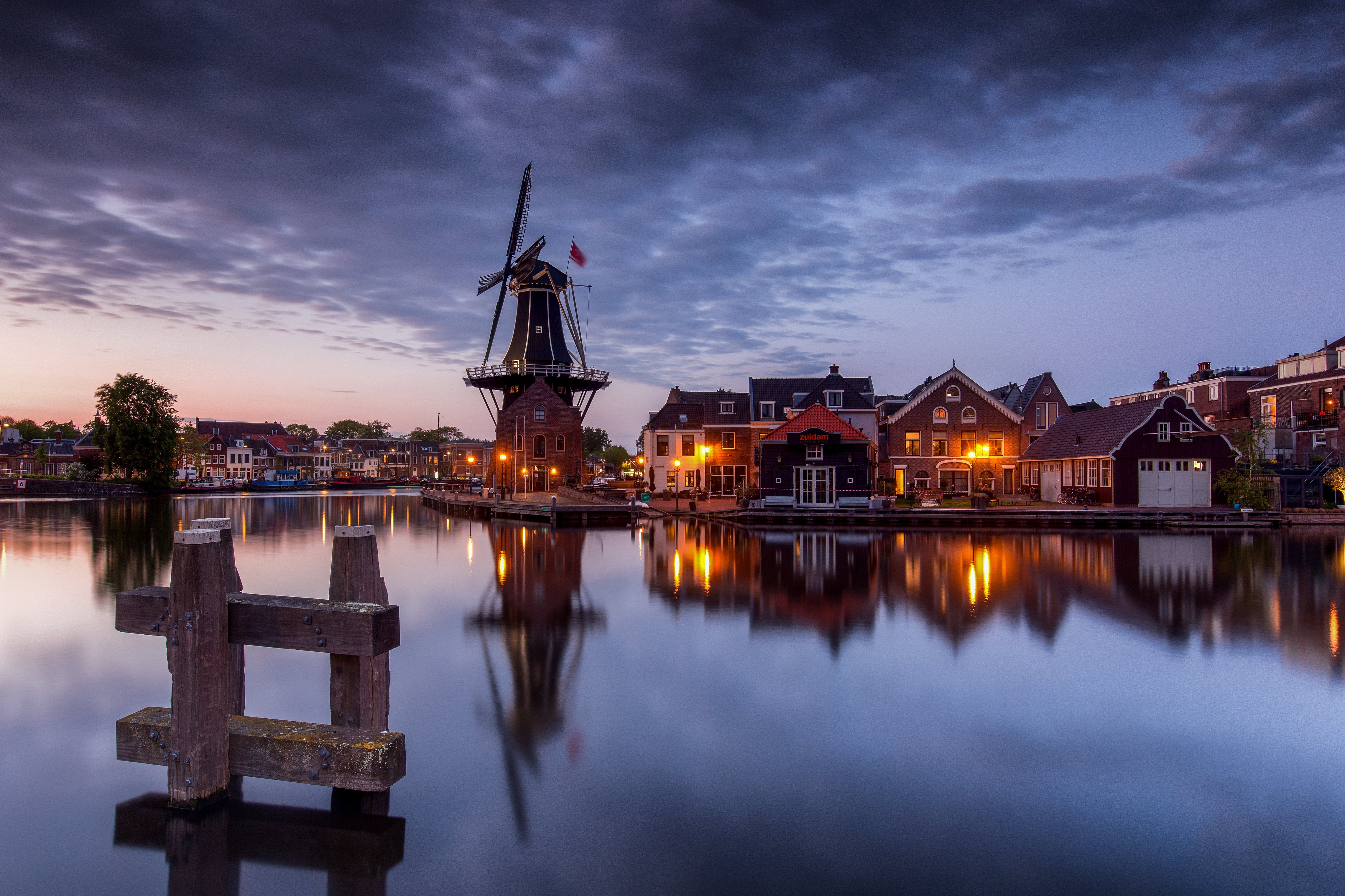 Windmill and houses on a canal in Haarlem at dusk HD Wallpaper