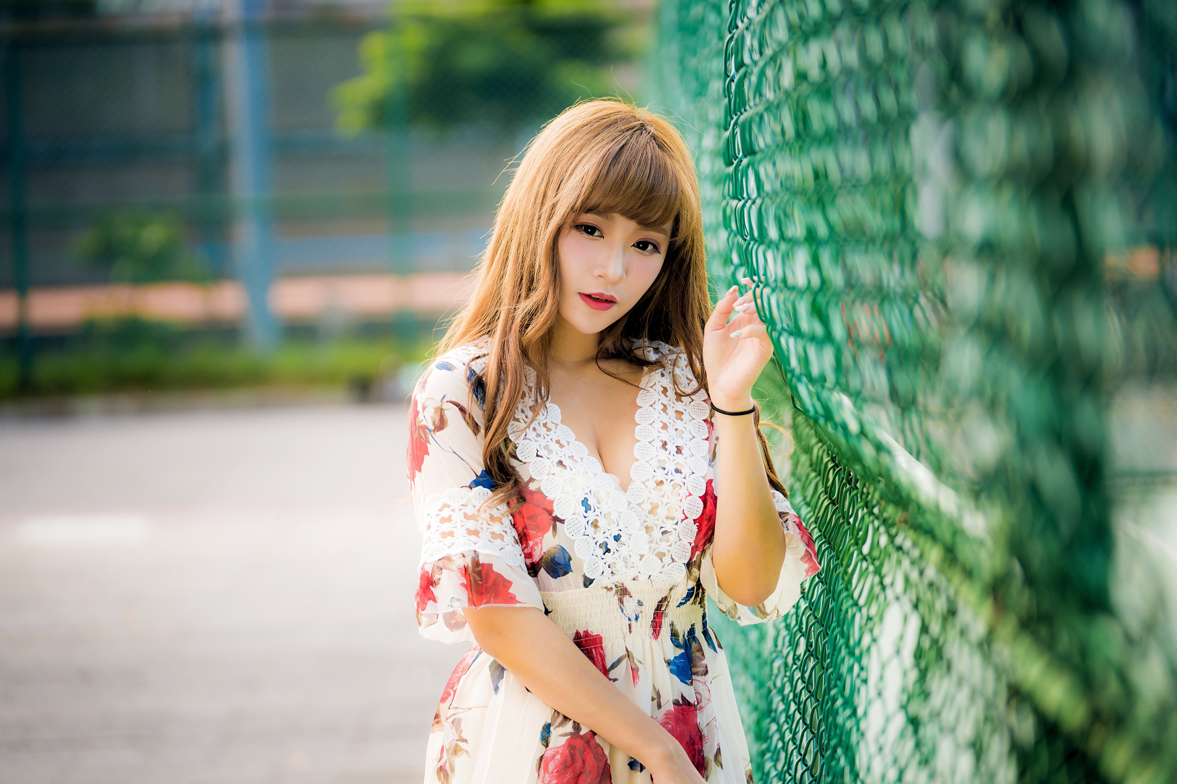 Asian woman in floral dress near fence HD Wallpaper
