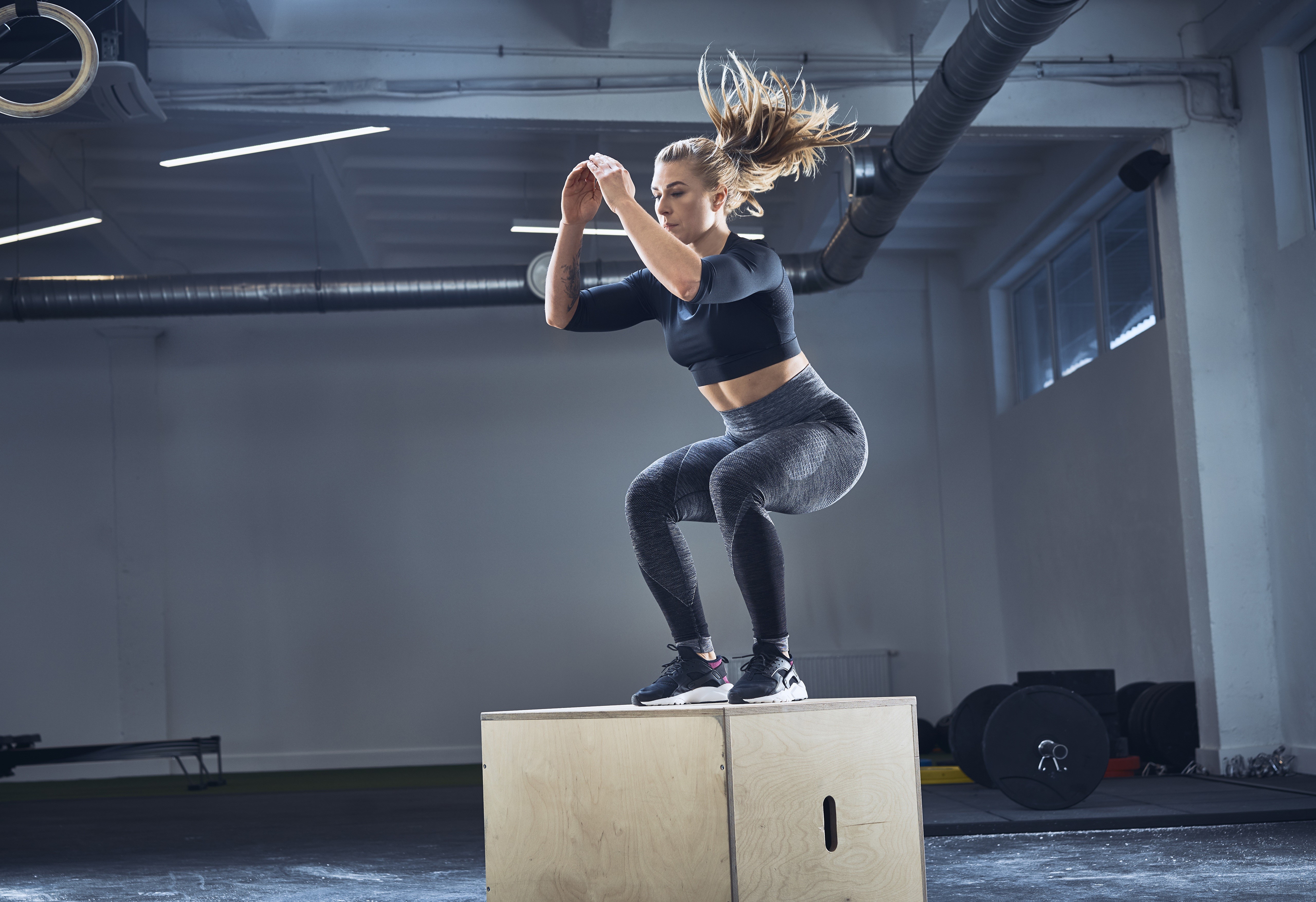 Woman performing box jump in a gym HD Wallpaper