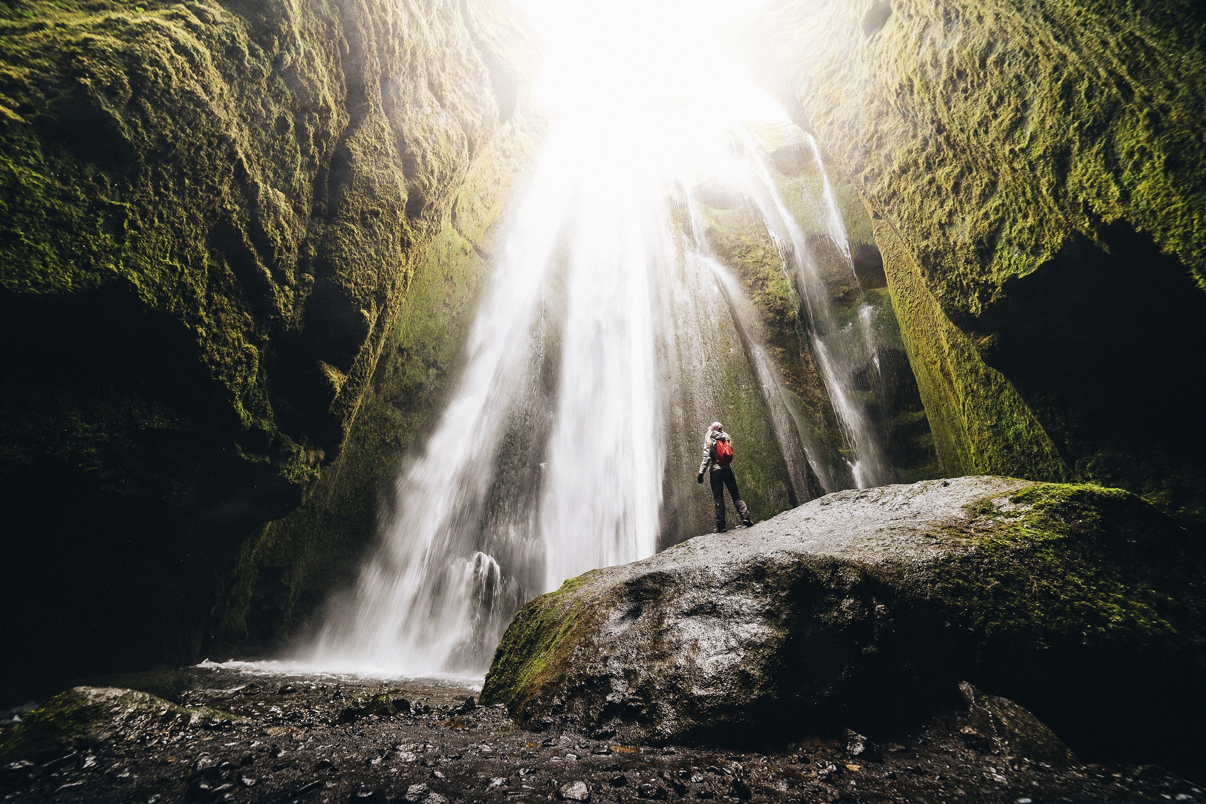Tourist at a Mossy Waterfall in Iceland HD Wallpaper