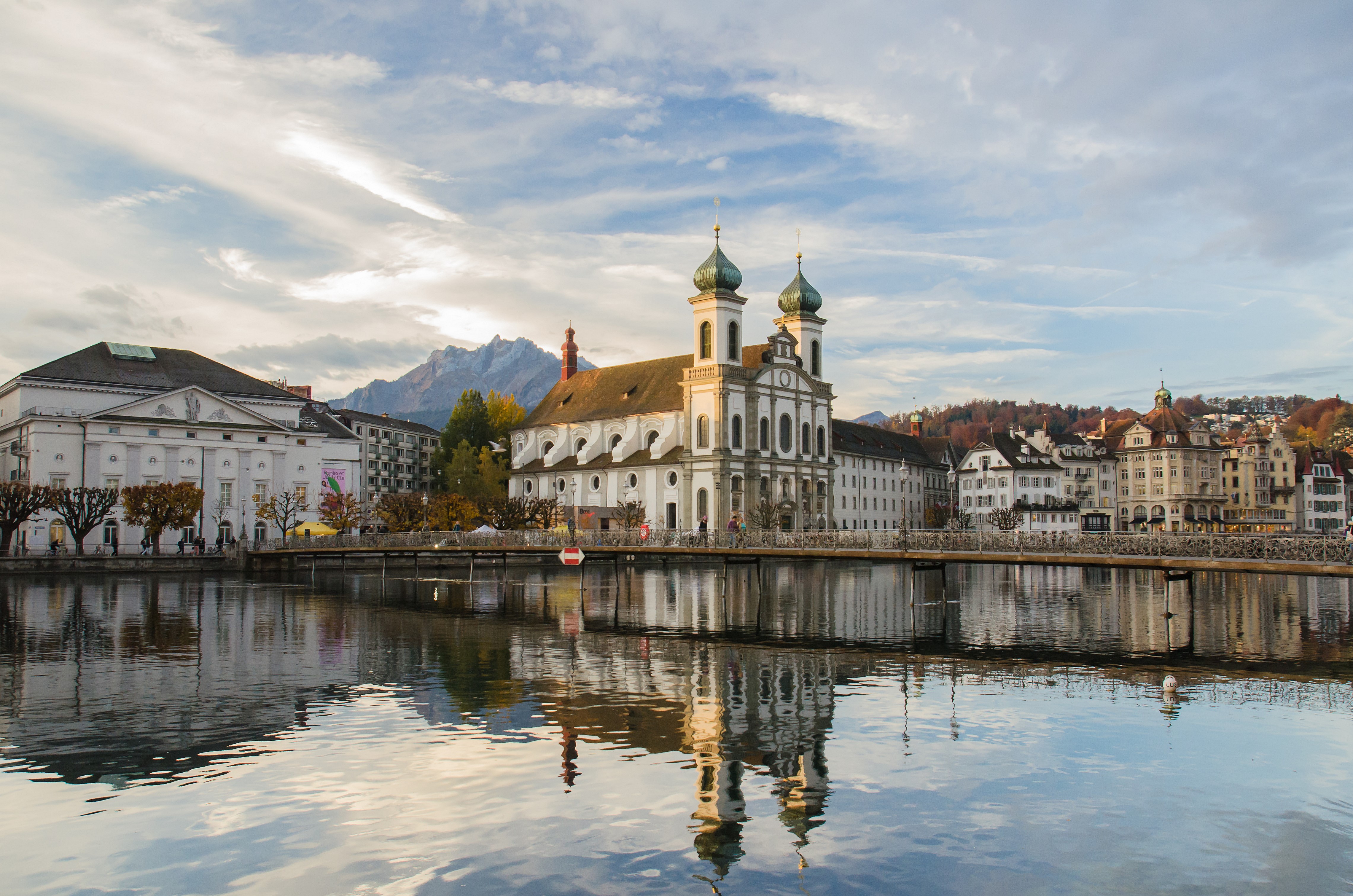 Jesuitenkirche and cityscape reflected in water, Luzern, Switzerland HD Wallpaper