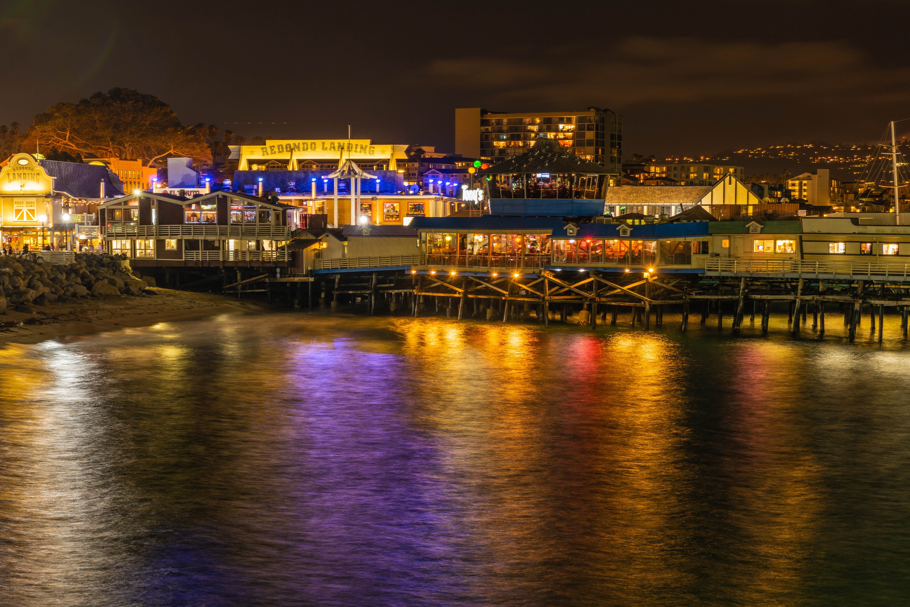 Redondo Landing pier at night with reflections on the water HD Wallpaper