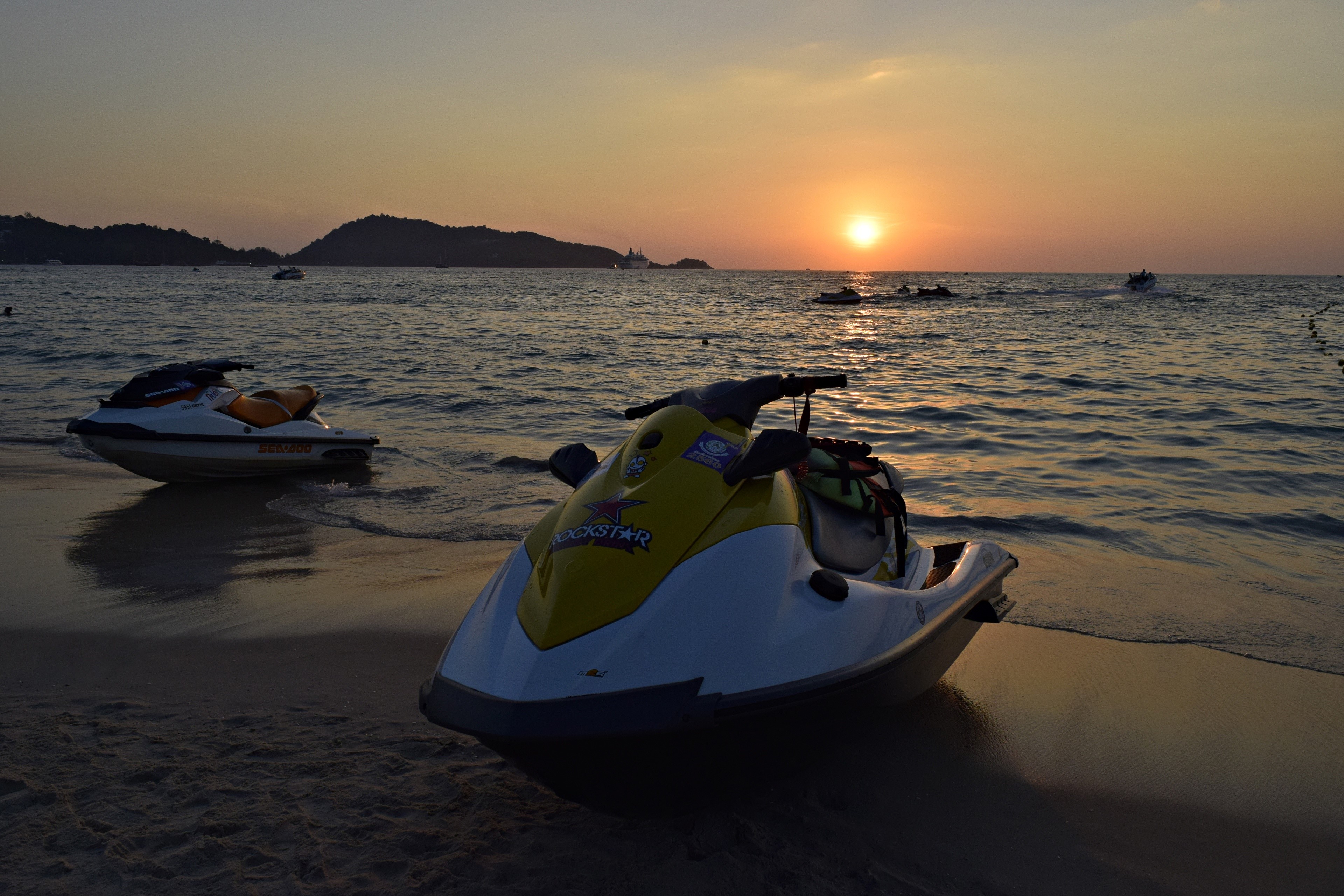 Jet skis on a beach at sunset HD Wallpaper
