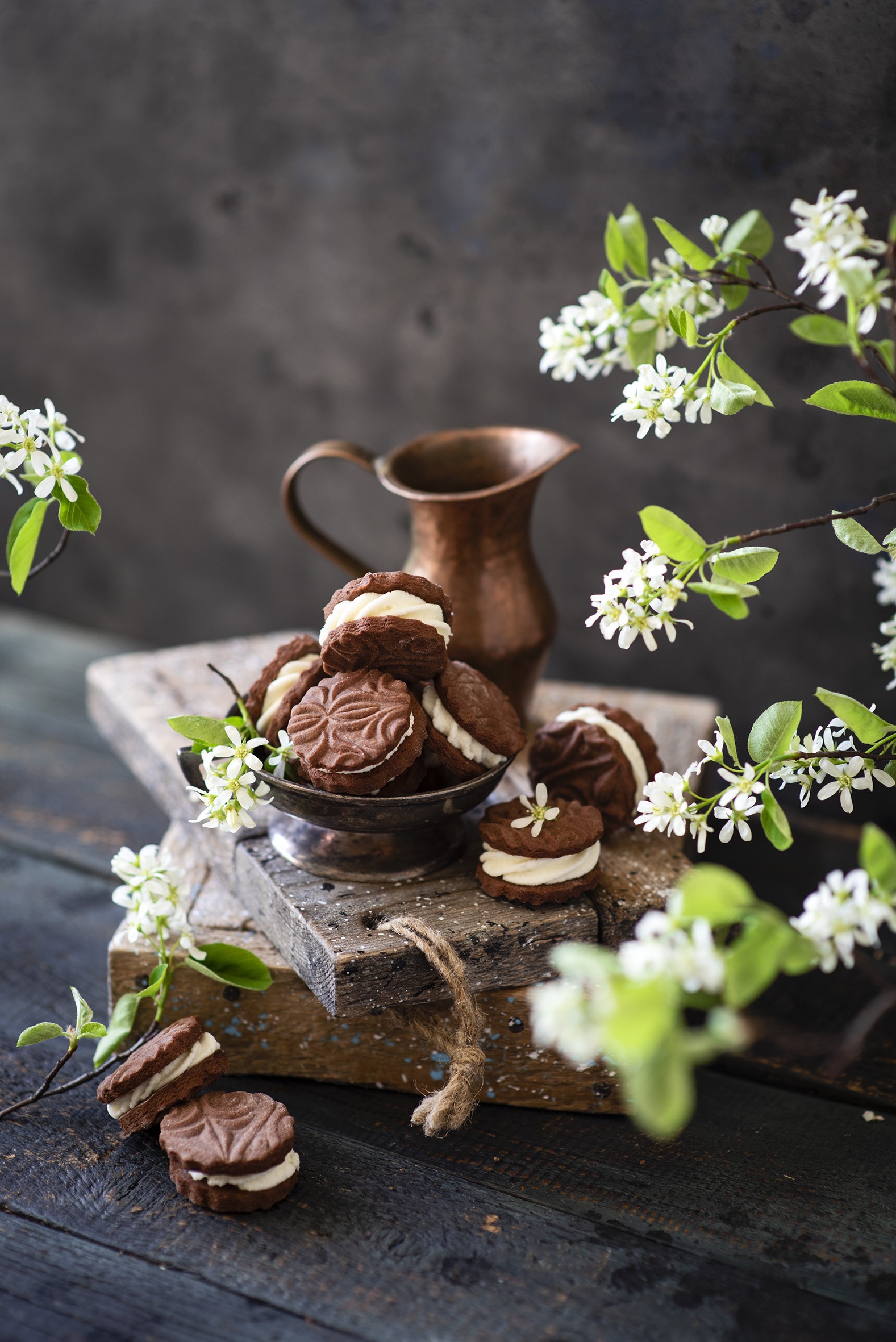 Chocolate cream cookies with white flowers and a copper jug HD Phone Wallpaper