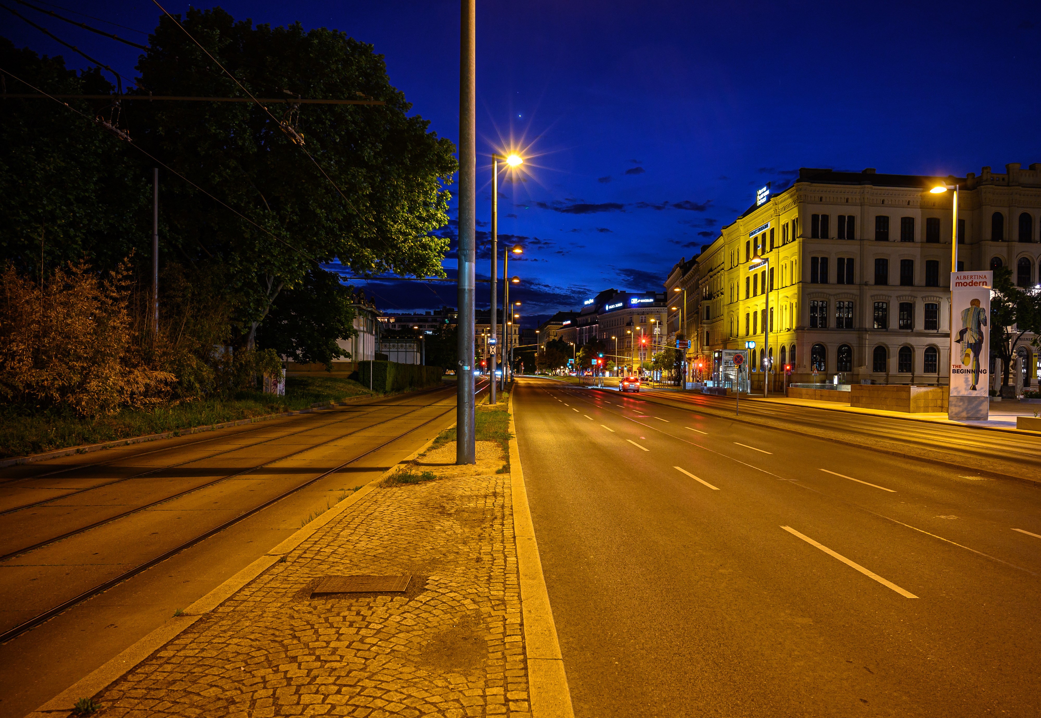 Vienna street at night with tram tracks and buildings HD Wallpaper