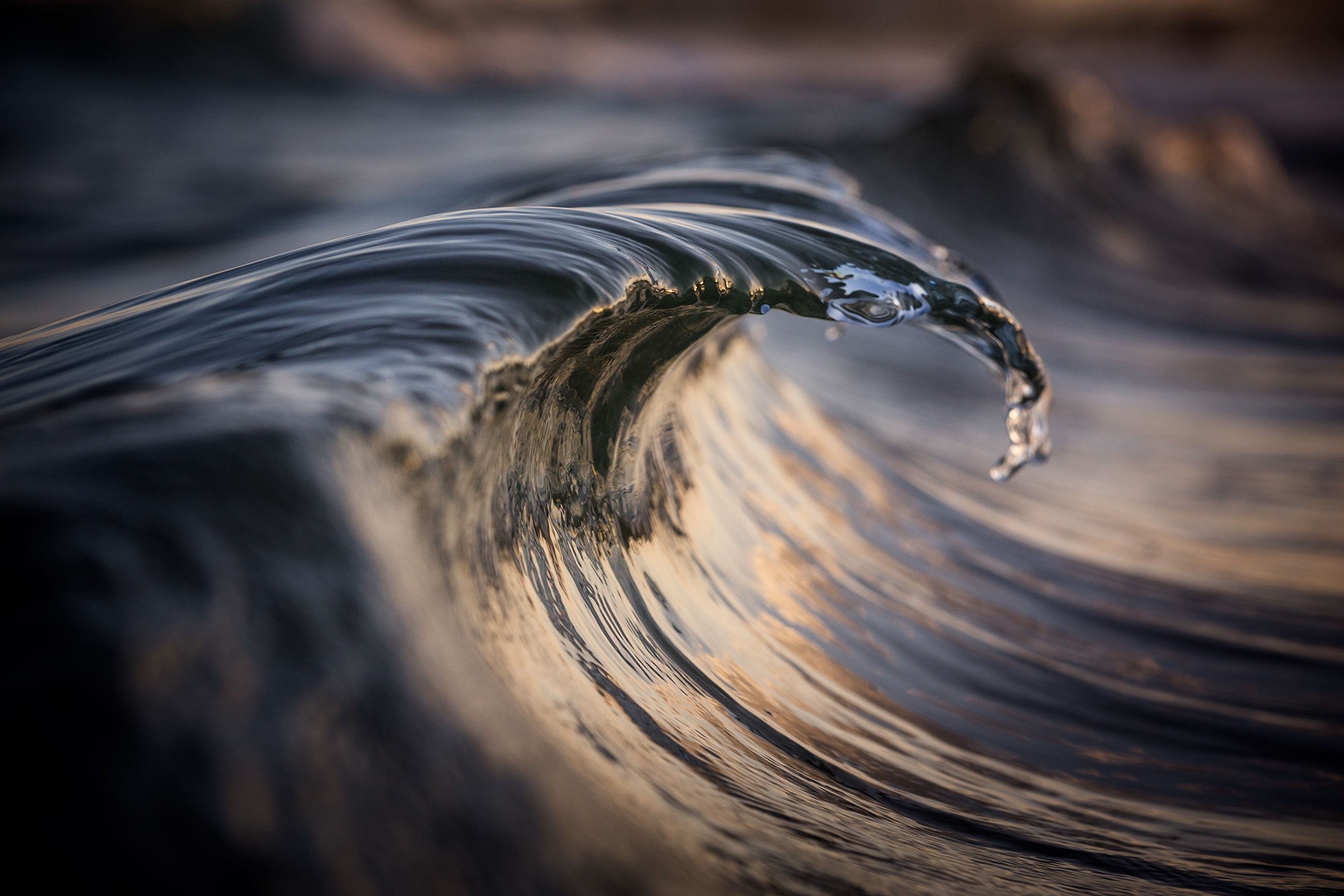 Close-up of a dark wave cresting with water droplets HD Wallpaper