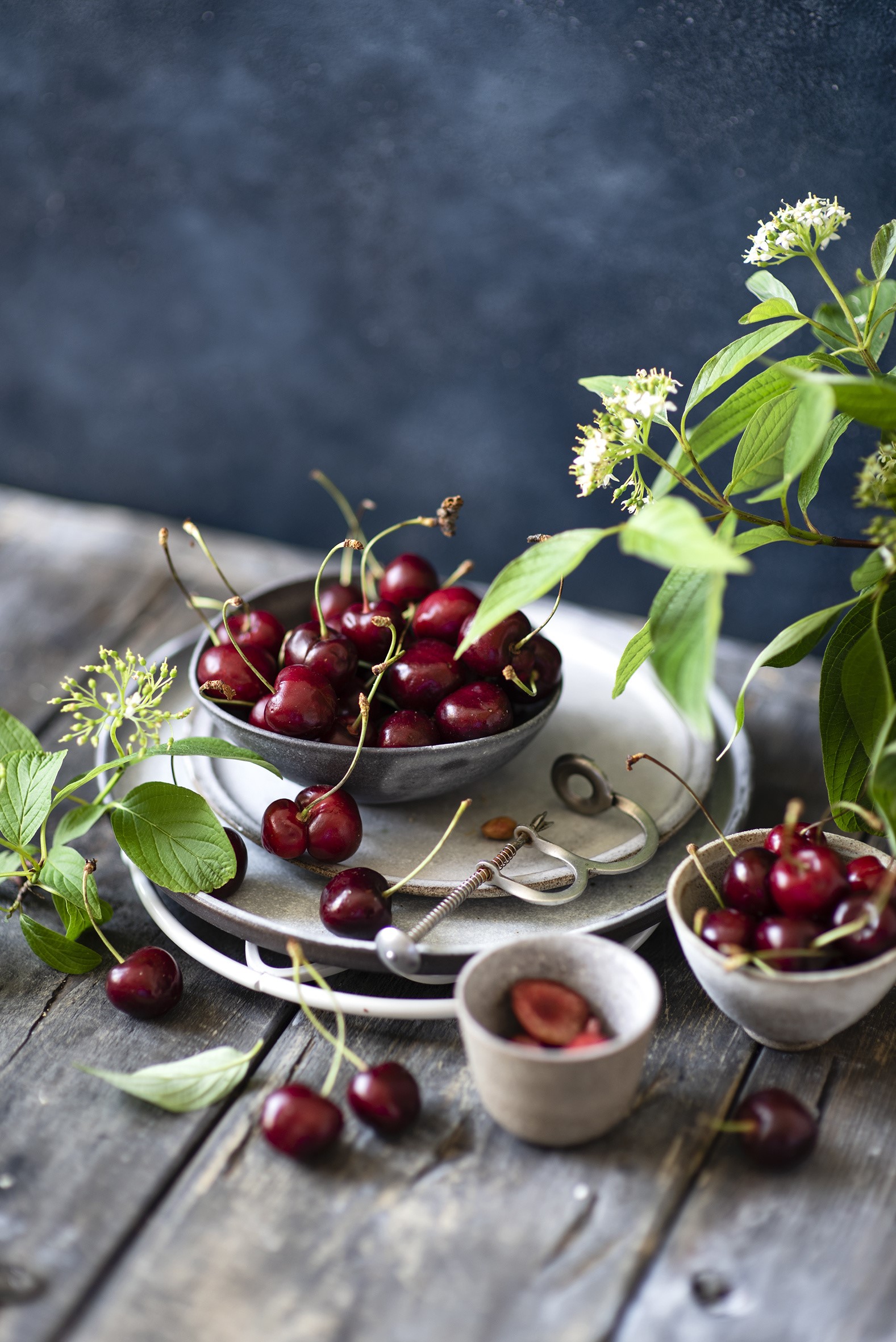 Cherries in bowls on wooden planks with flowers HD Phone Wallpaper