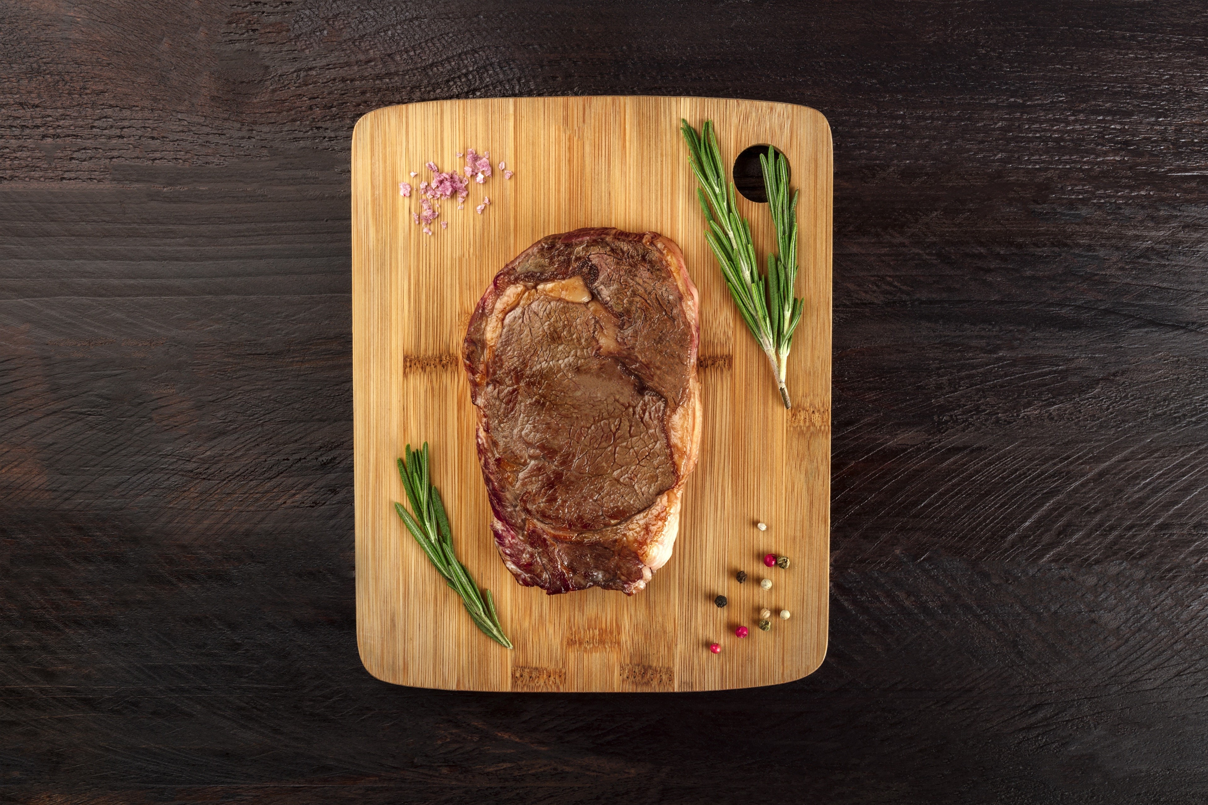 Raw steak with rosemary and spices on a cutting board HD Wallpaper