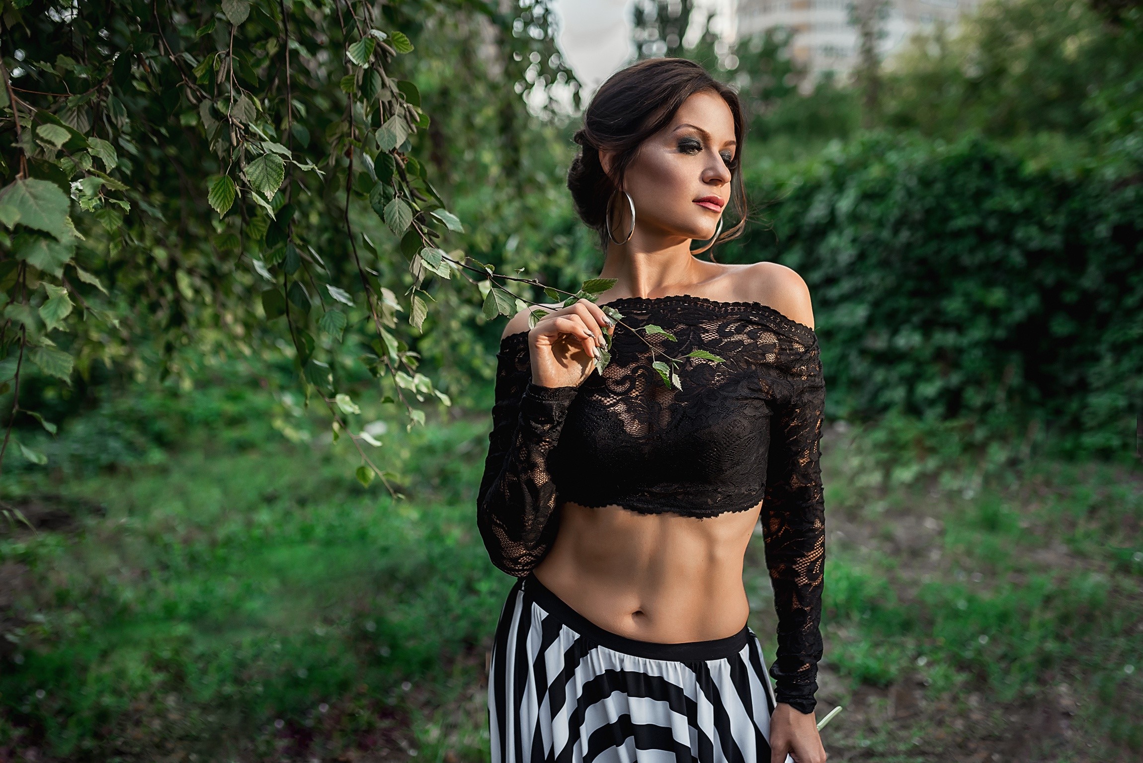 Model Georgiy Dyakov posing in a black lace blouse and striped skirt HD Wallpaper