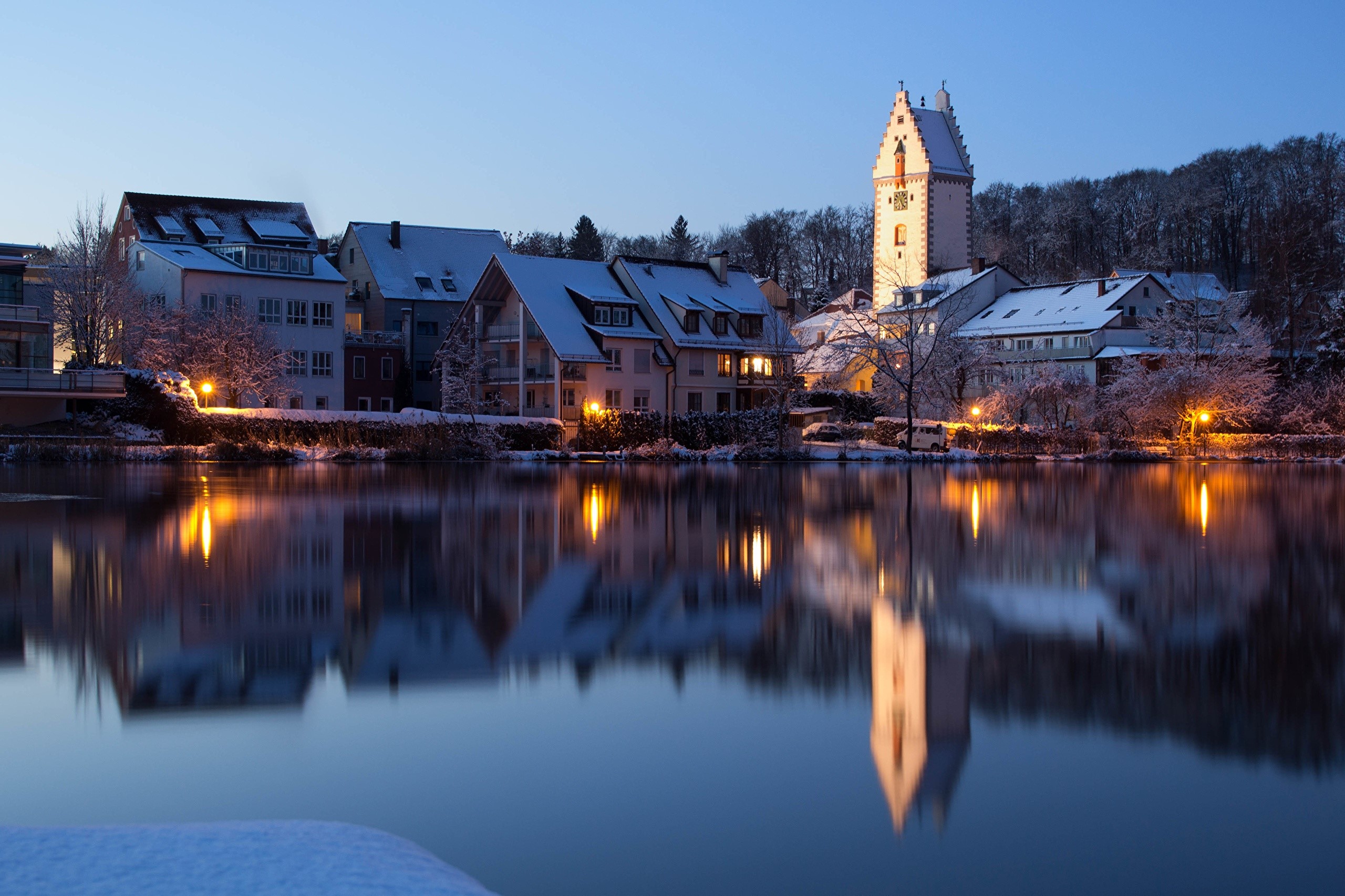 Houses and tower reflected in a lake at dusk in Germany HD Wallpaper