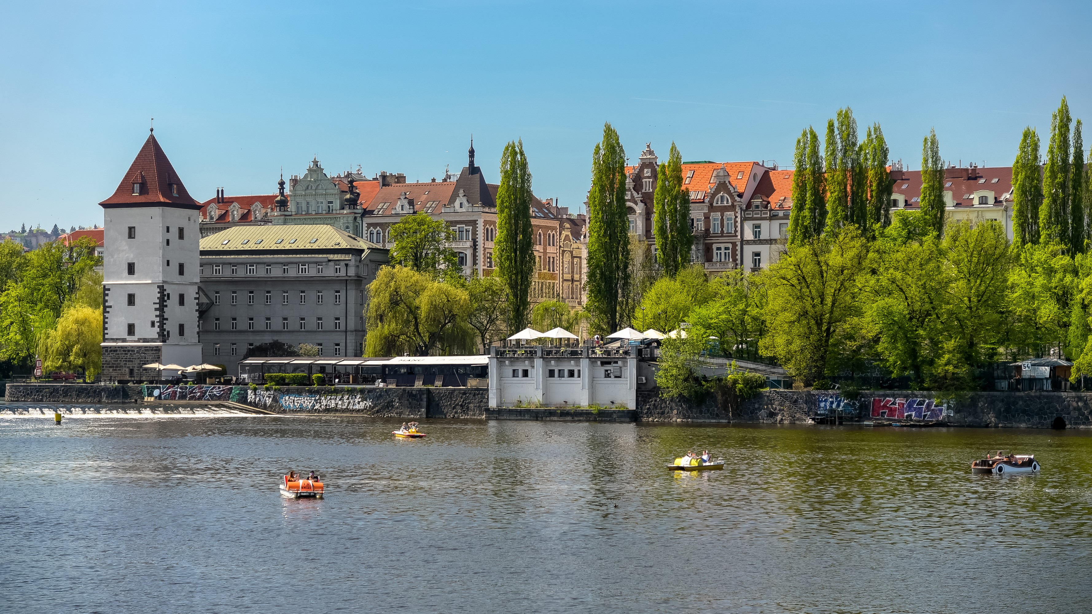Prague riverfront with buildings and boats HD Wallpaper