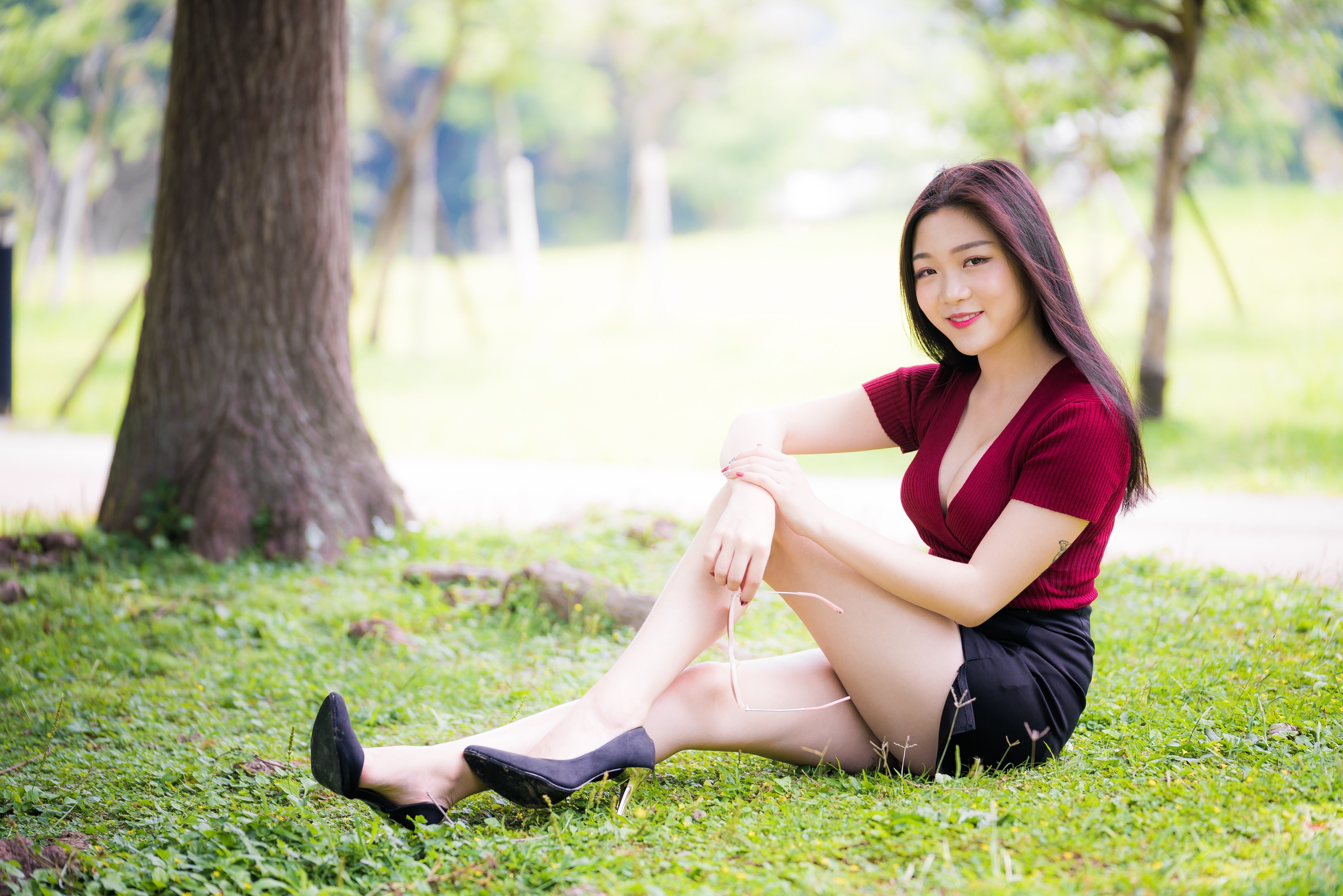 4K Asian Woman Sitting on Grass in Stilettos HD Wallpaper