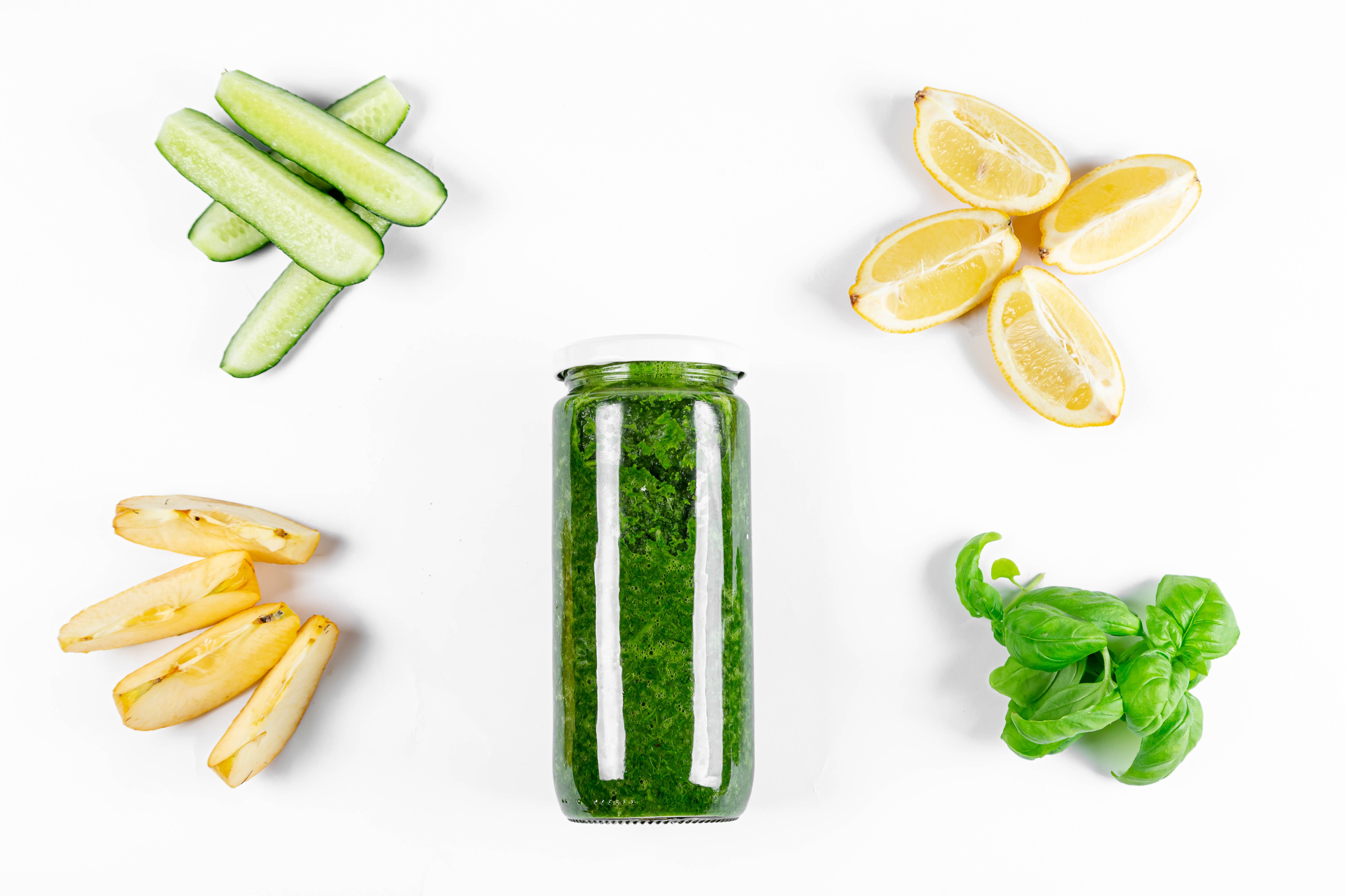 Jar of green smoothie with cucumbers, lemons, apples, and basil HD Wallpaper