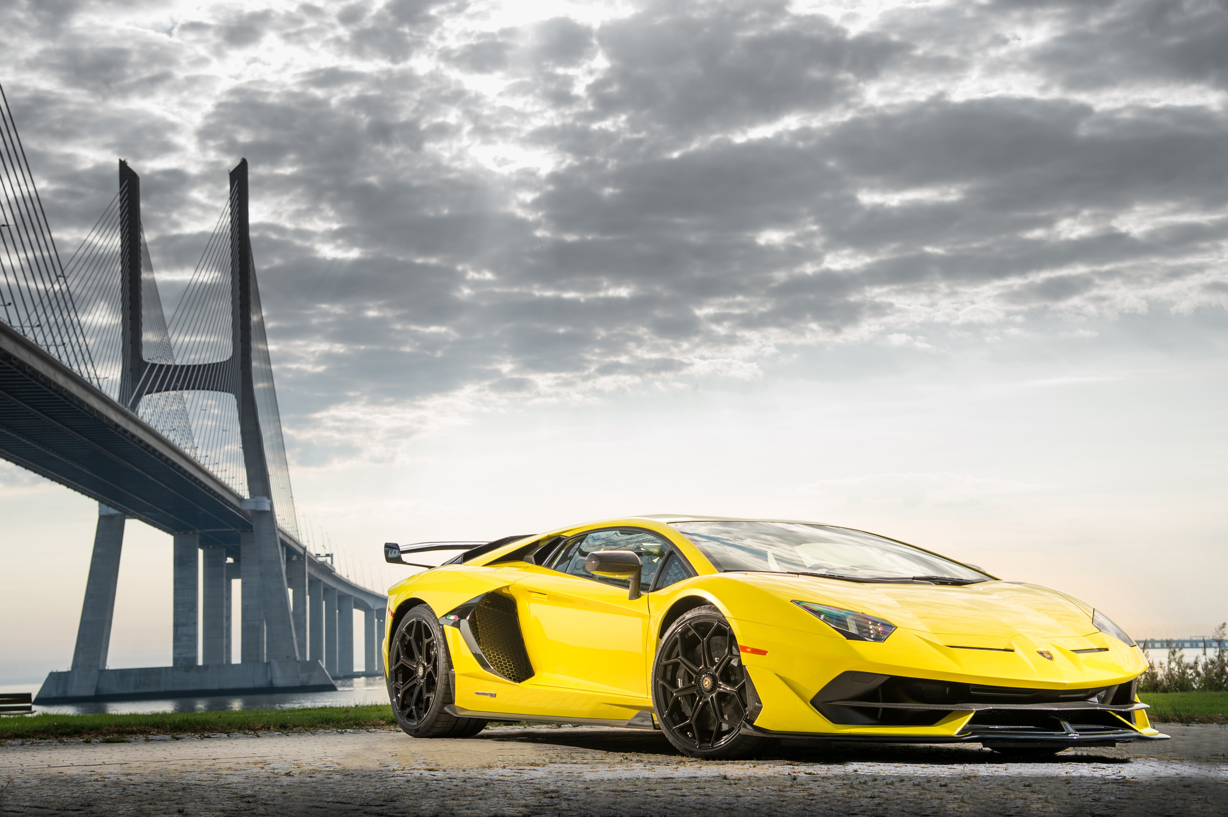 Yellow Lamborghini Aventador near a bridge HD Wallpaper