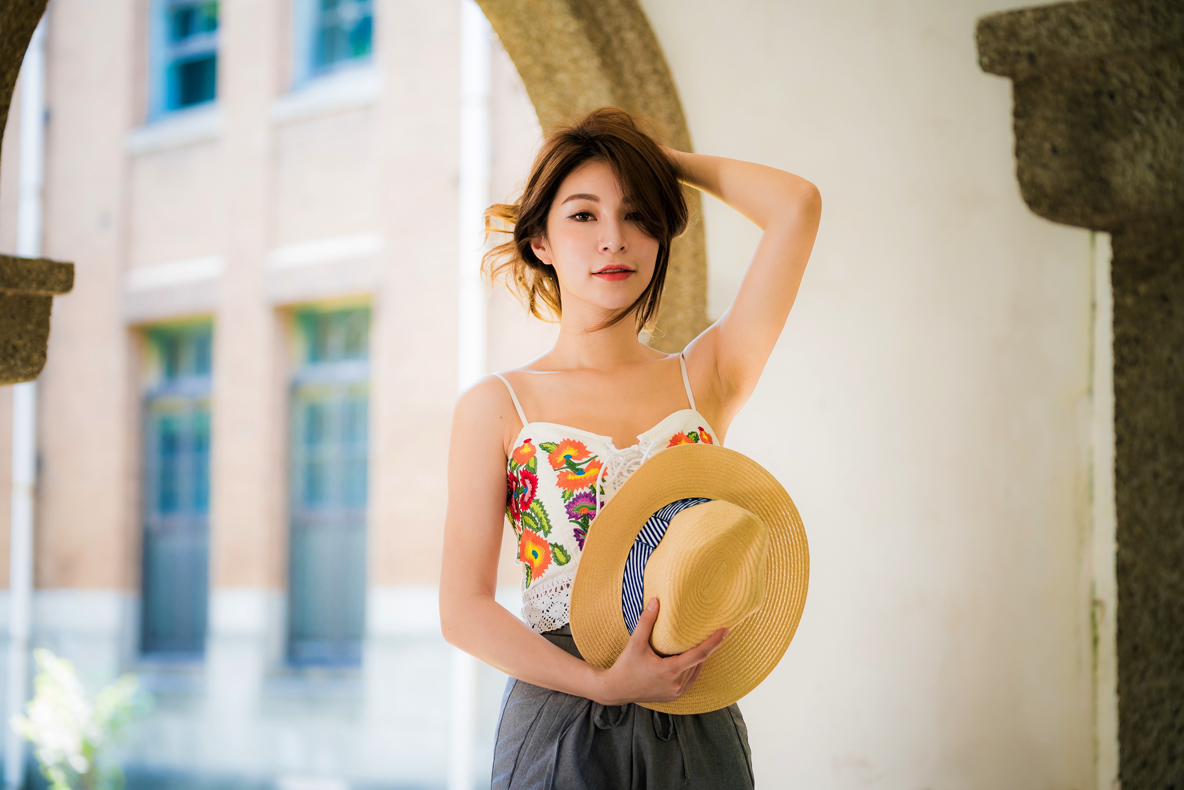 Asian woman with brown hair holding a hat HD Wallpaper