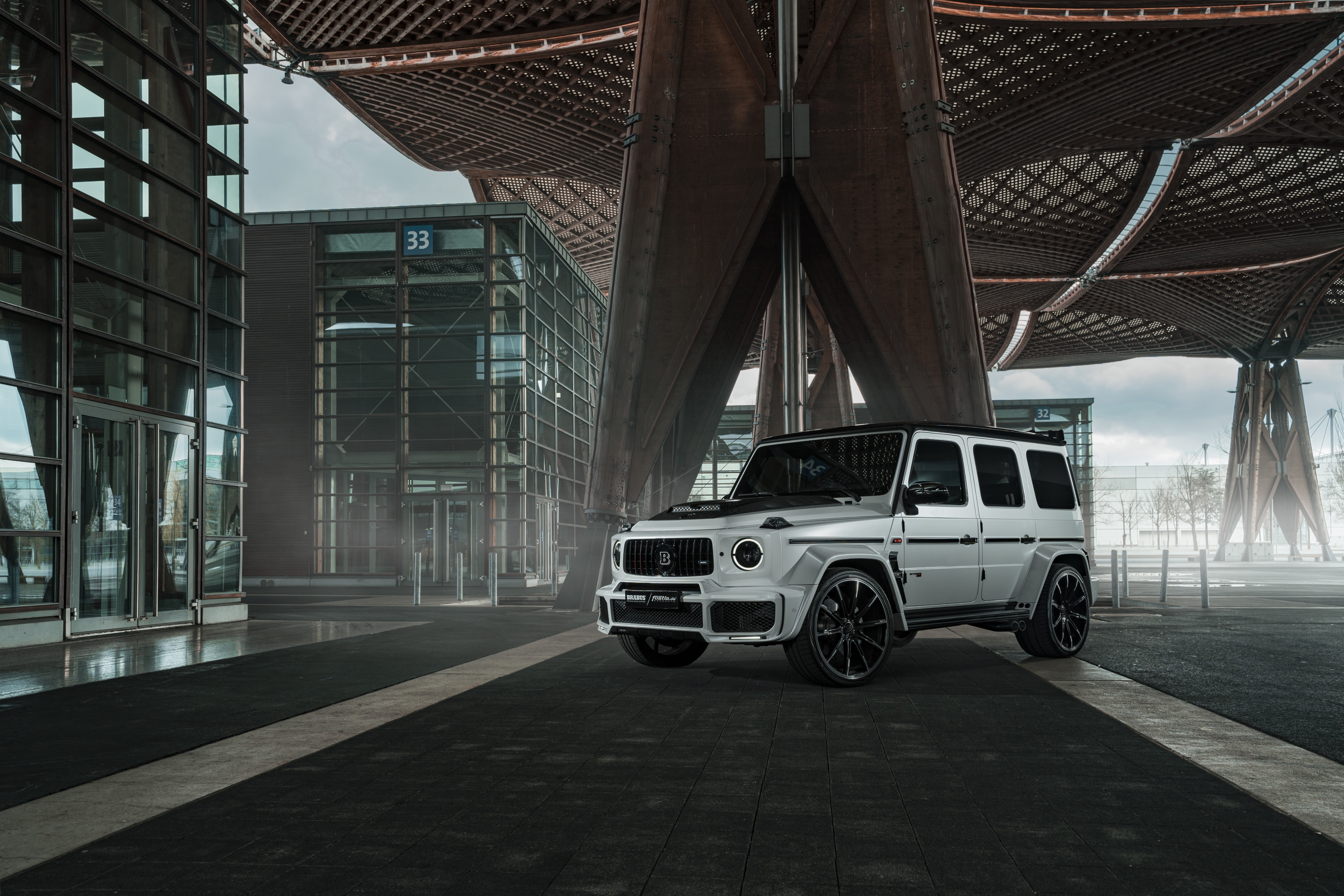 White Brabus 700 Widestar SUV parked near modern architecture HD Wallpaper