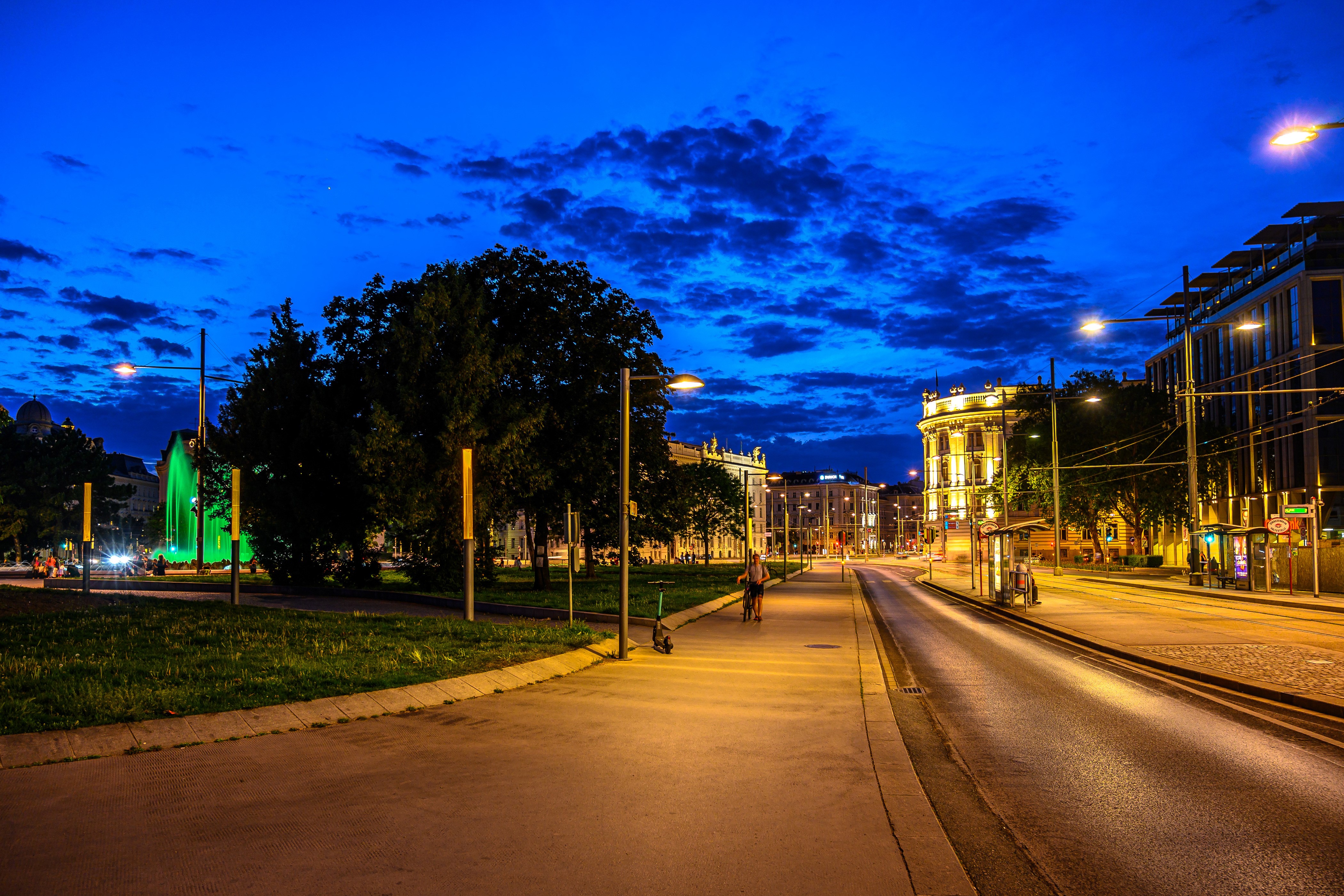 Vienna street at dusk with fountain and buildings HD Wallpaper