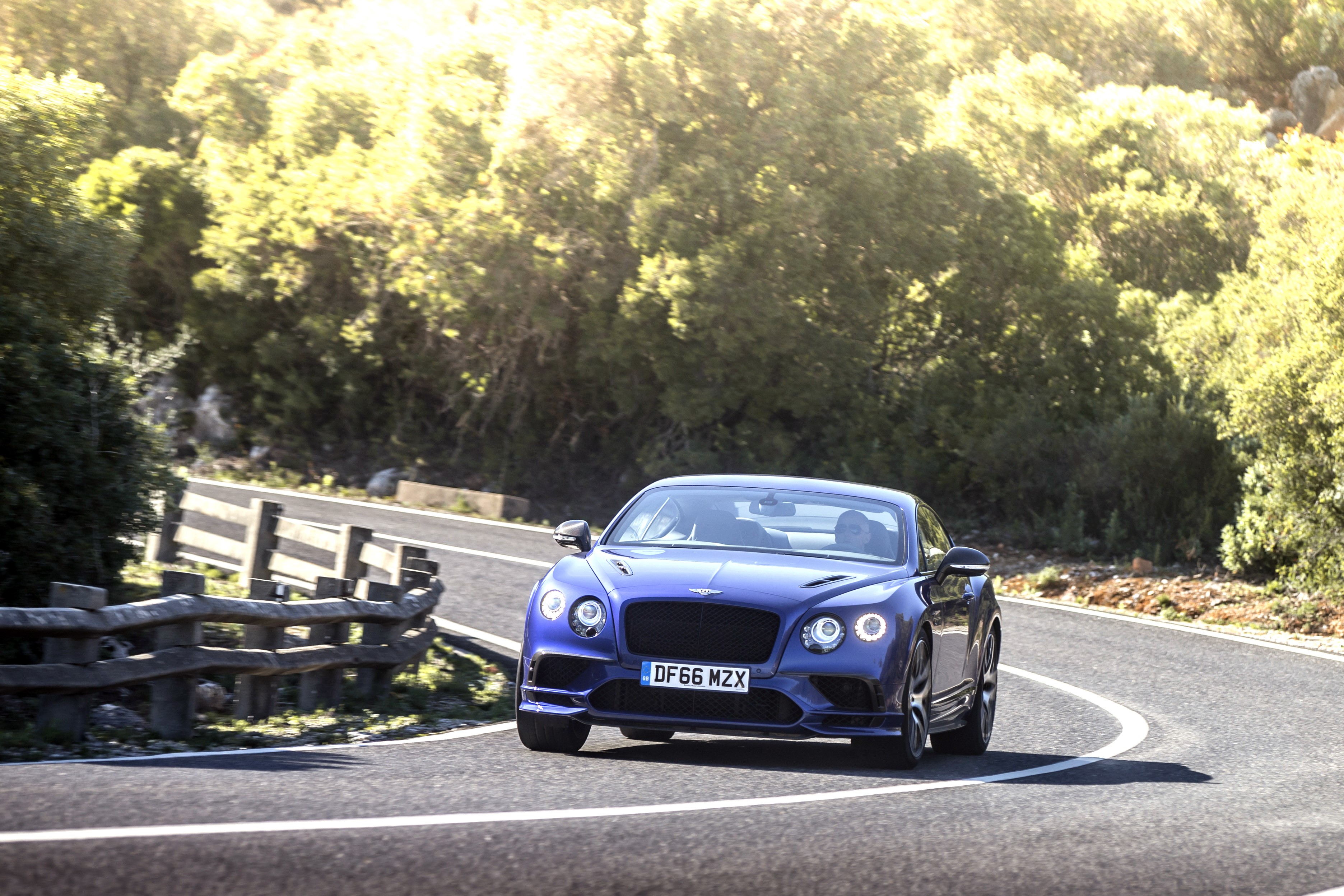 Blue Bentley Continental GT Supersport driving on a winding road HD Wallpaper